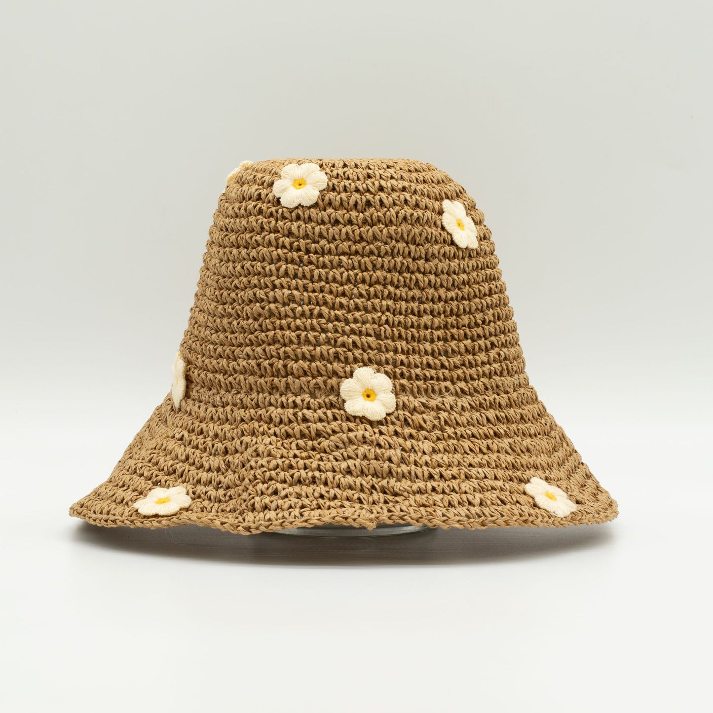 Sombrero de paja marrón con flores bordadas en blanco y amarillo, estilo veraniego y casual.