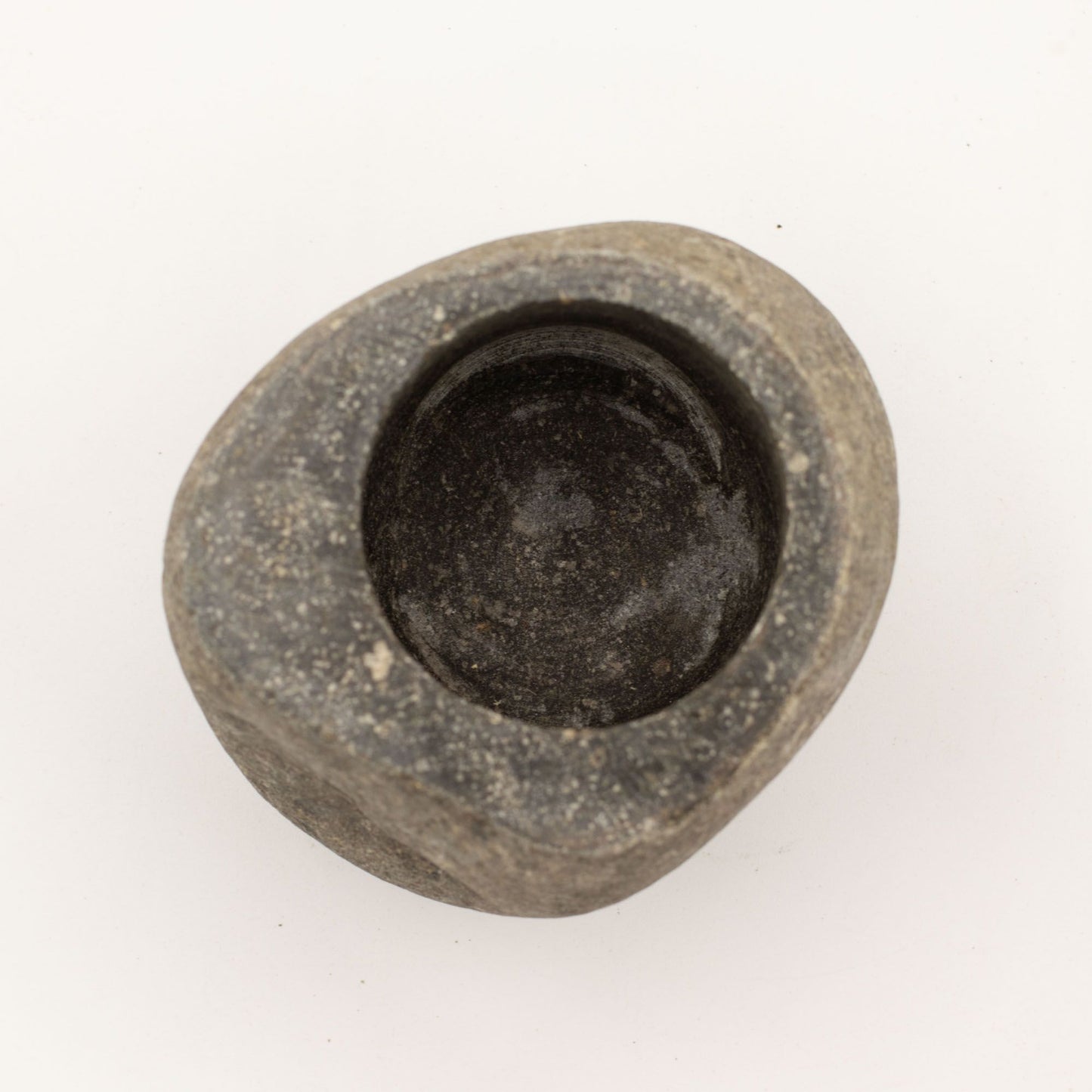 Tazón irregular de piedra negra, acabado mate, ideal para decoración o cocina, diseño artesanal único.