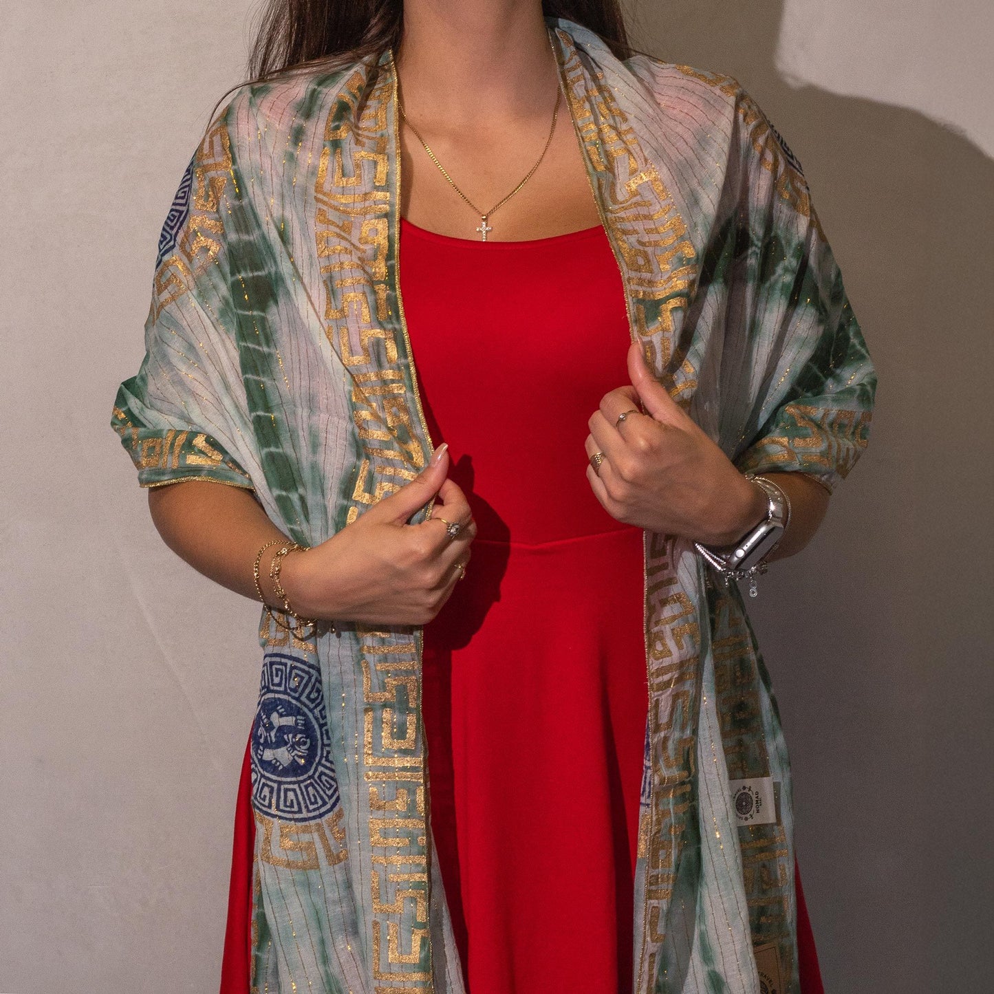 Chal verde y dorado con estampado griego, ideal para complementar vestido rojo. Perfecto para ocasiones elegantes.