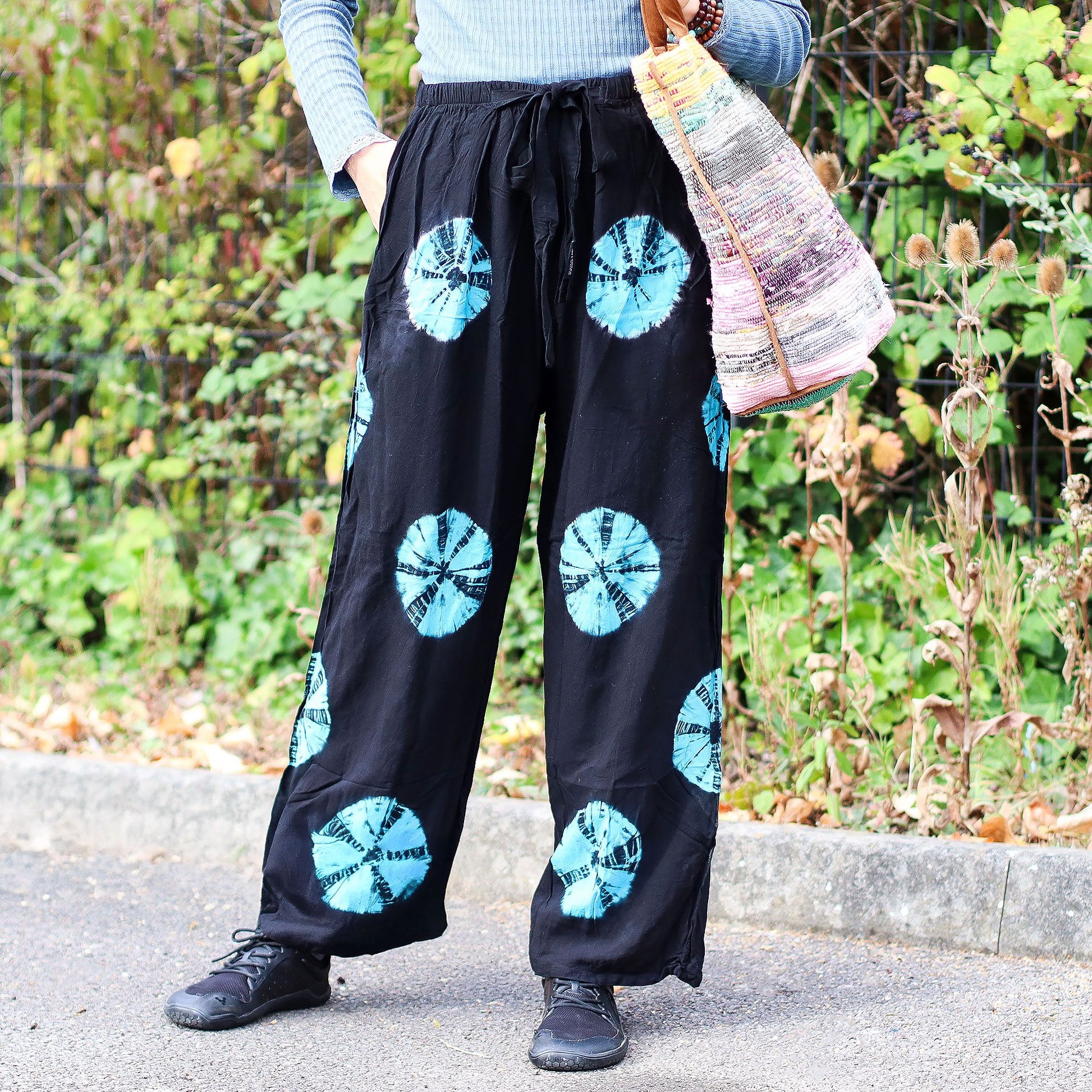 Pantalones de descanso Ancient Wisdom negros de corte holgado con estampado tie-dye azul y cintura elástica ajustable.