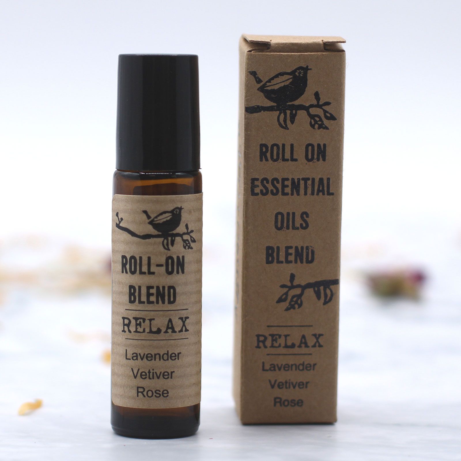 Aceite esencial en roll-on de lavanda, vetiver y rosa, en envase marrón con etiqueta negra, estilo natural y relajante.