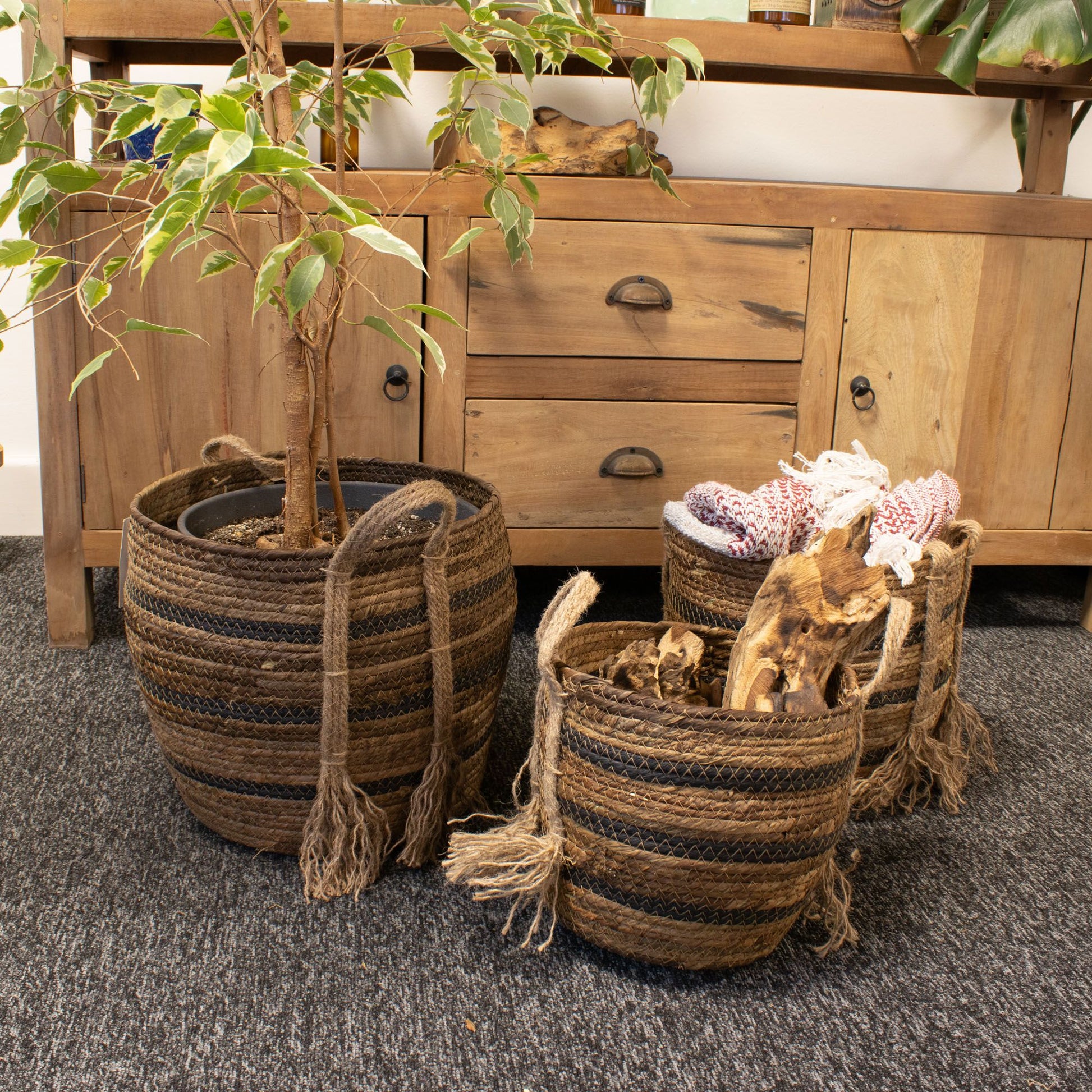 Set de 3 cestas tejidas de hoja de plátano y pasto marino marrón, con asas decorativas y estilo natural rústico.