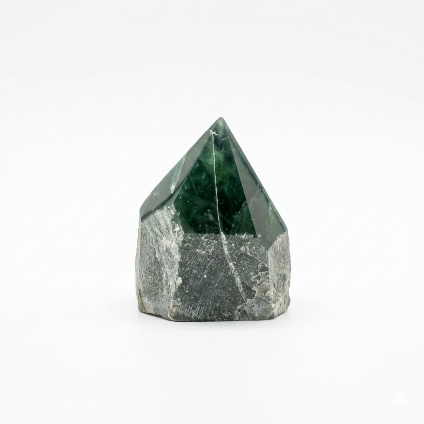 Piedra preciosa de cuarzo verde oscuro en forma de pirámide, con base gris y textura natural.