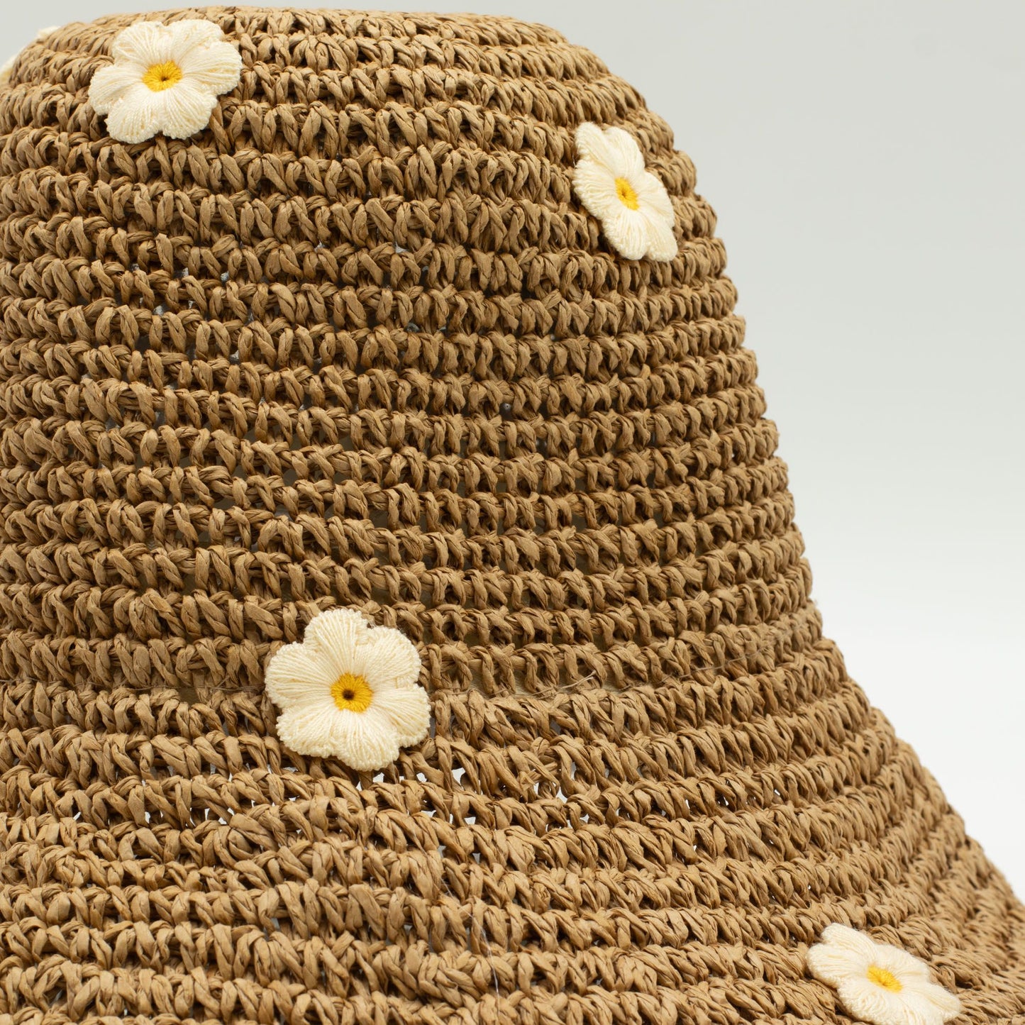 Sombrero de paja marrón con flores bordadas amarillas; estilo bohemio y ligero, ideal para el verano.