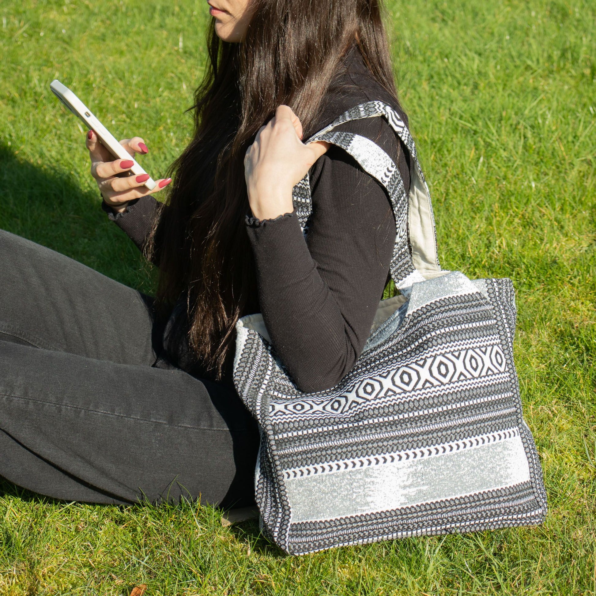 Bolso de tela negro y blanco con diseño geométrico, ideal para uso diario y estilo bohemio.