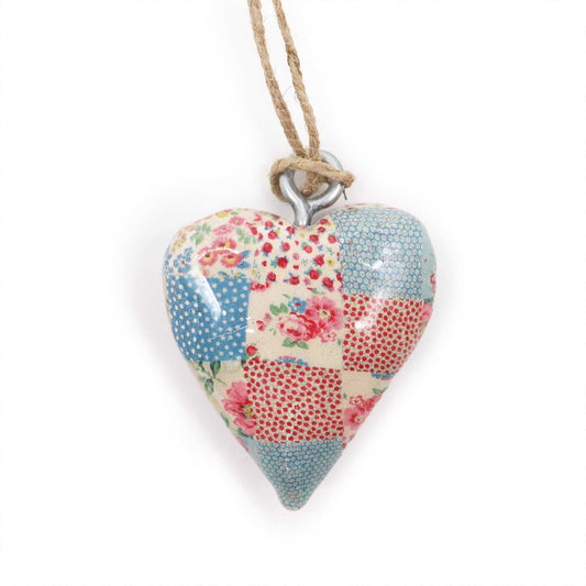 Corazón de cerámica en patchwork con tonos rojos, azules y florales, colgado con cuerda de yute.