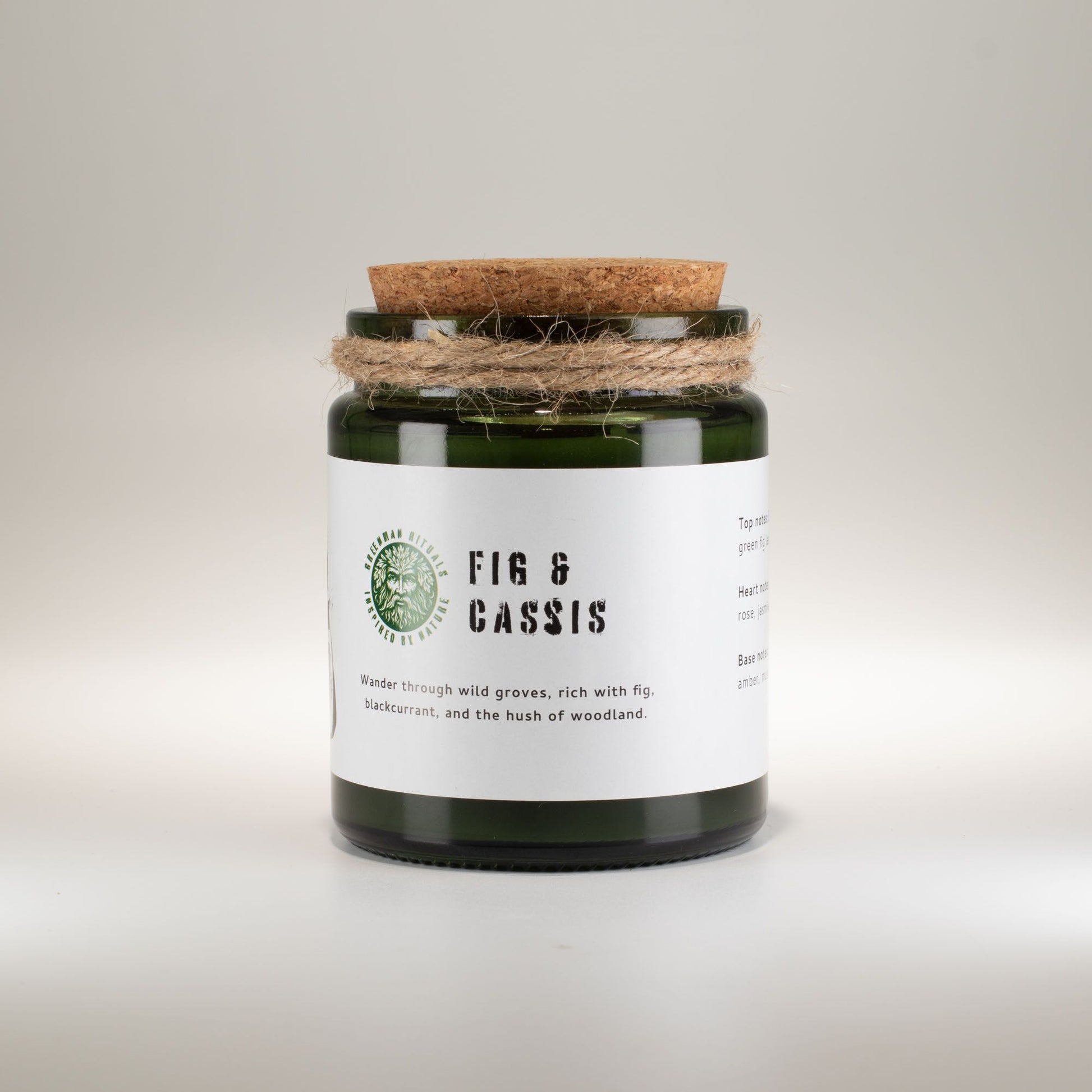 Vela de cristal verde con tapa de corcho, aroma higo y grosella negra, estilo rústico.