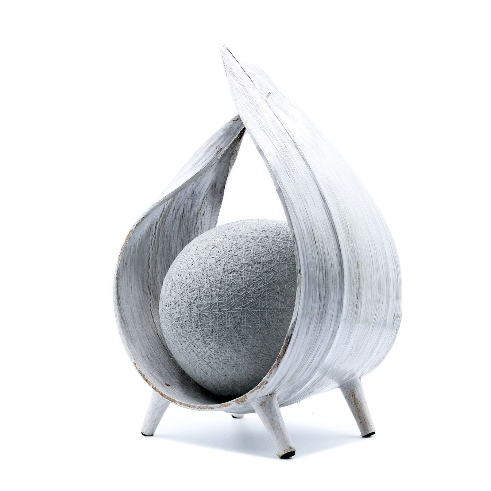 Escultura moderna de madera blanca con forma de gota y esfera gris en el interior, estilo minimalista.