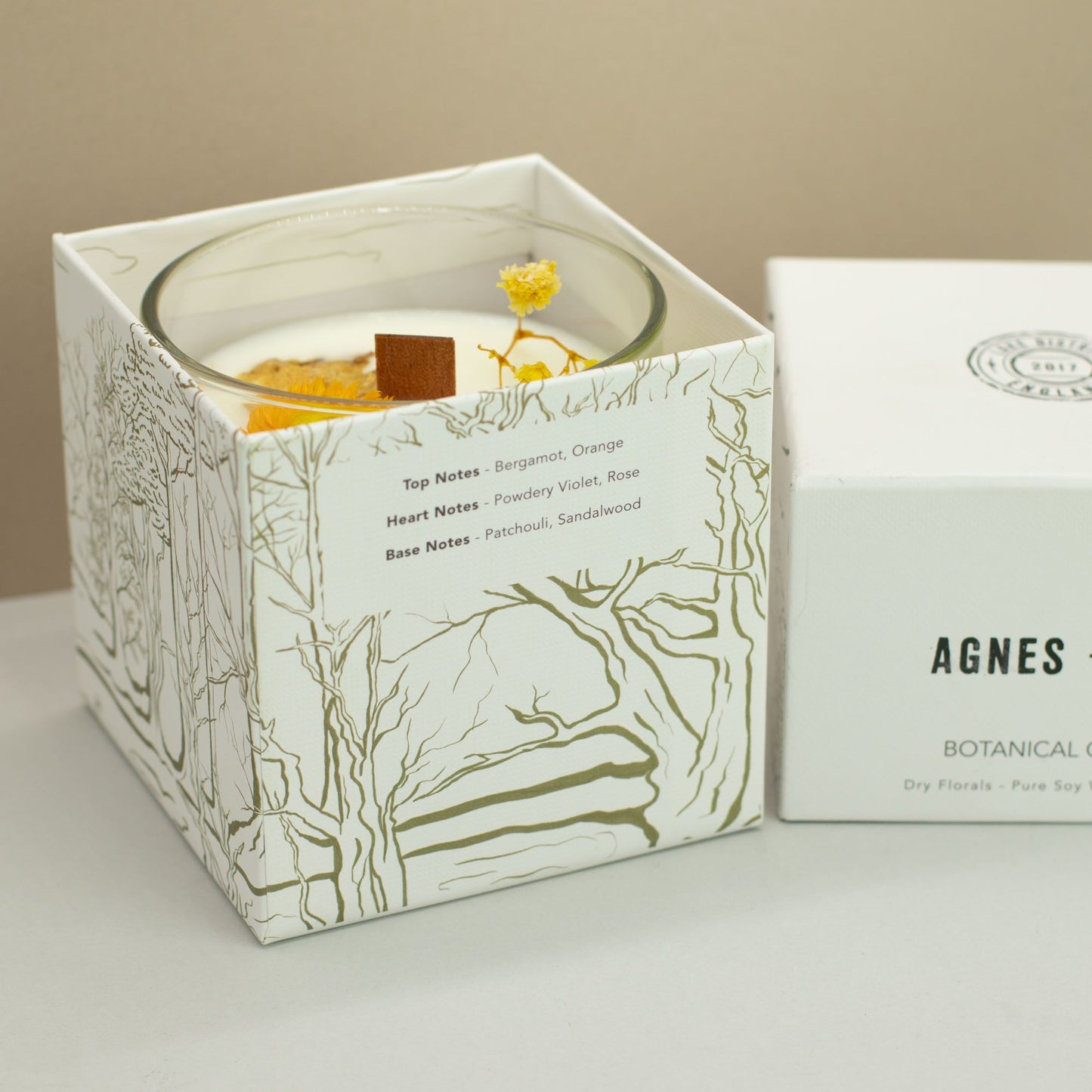 Vela de soja Botánica Agnes, con notas de bergamota, color blanco y envase decorativo elegante.
