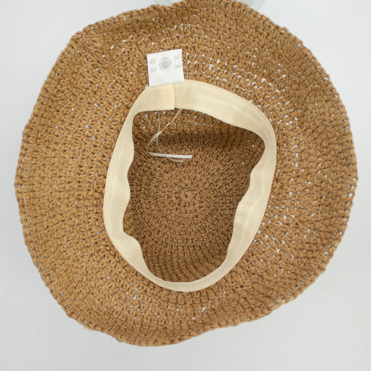 Sombrero de paja trenzada en color marrón con borde beige, estilo bohemio y ligero, ideal para el verano.