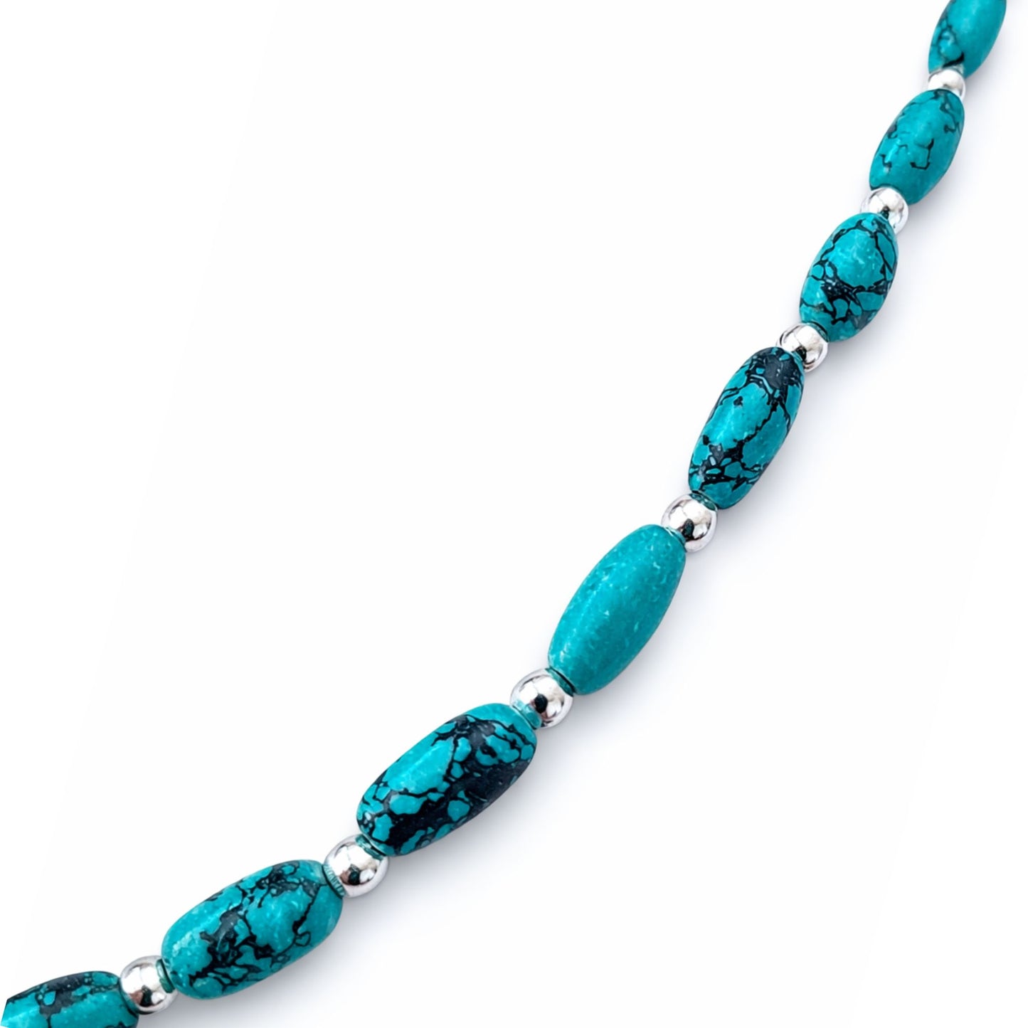 Collar de turquesa azul con cuentas ovaladas y separadores plateados, estilo elegante y moderno.