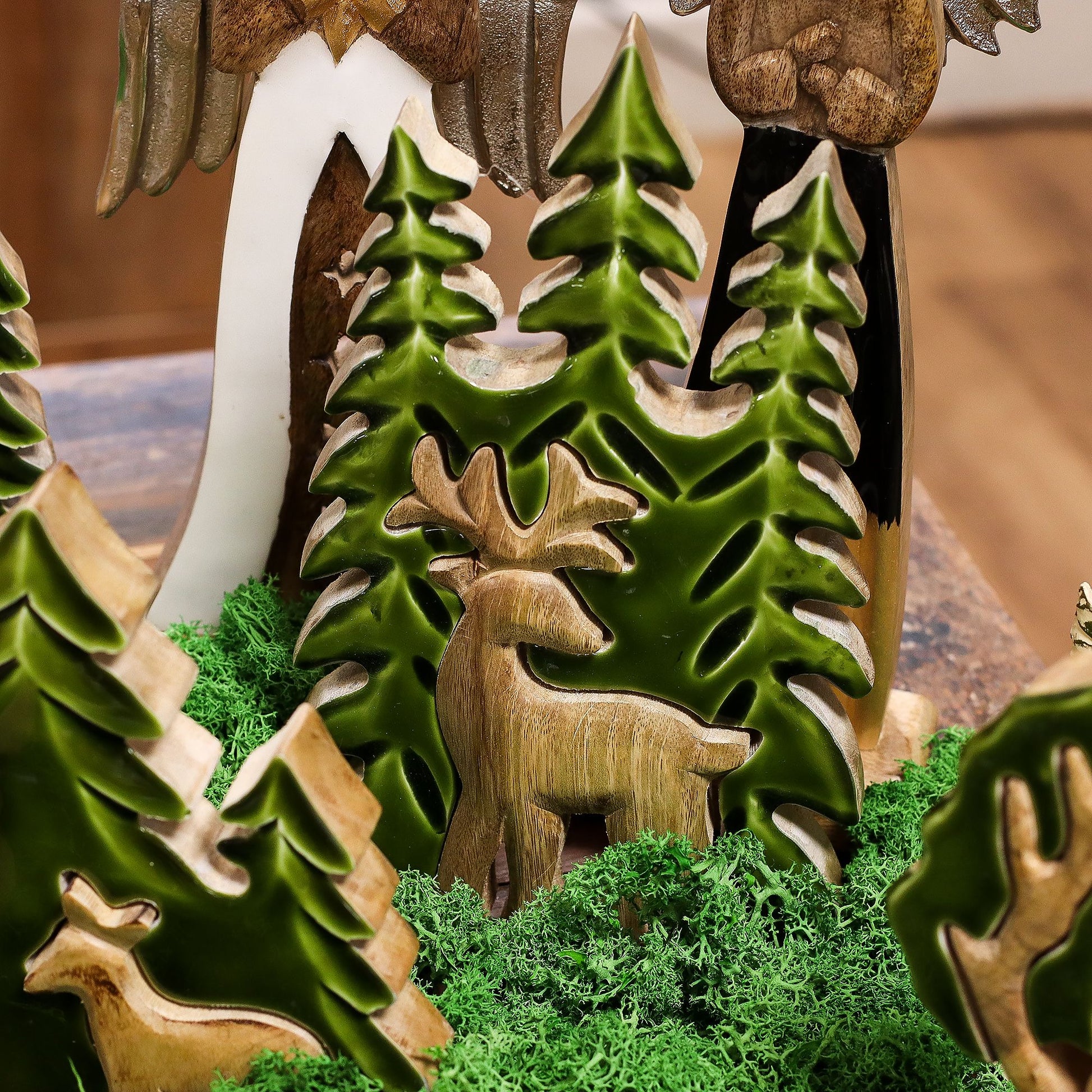 Adorno decorativo de ciervo en madera y resina verde, con árboles verdes y musgo, estilo rústico navideño.
