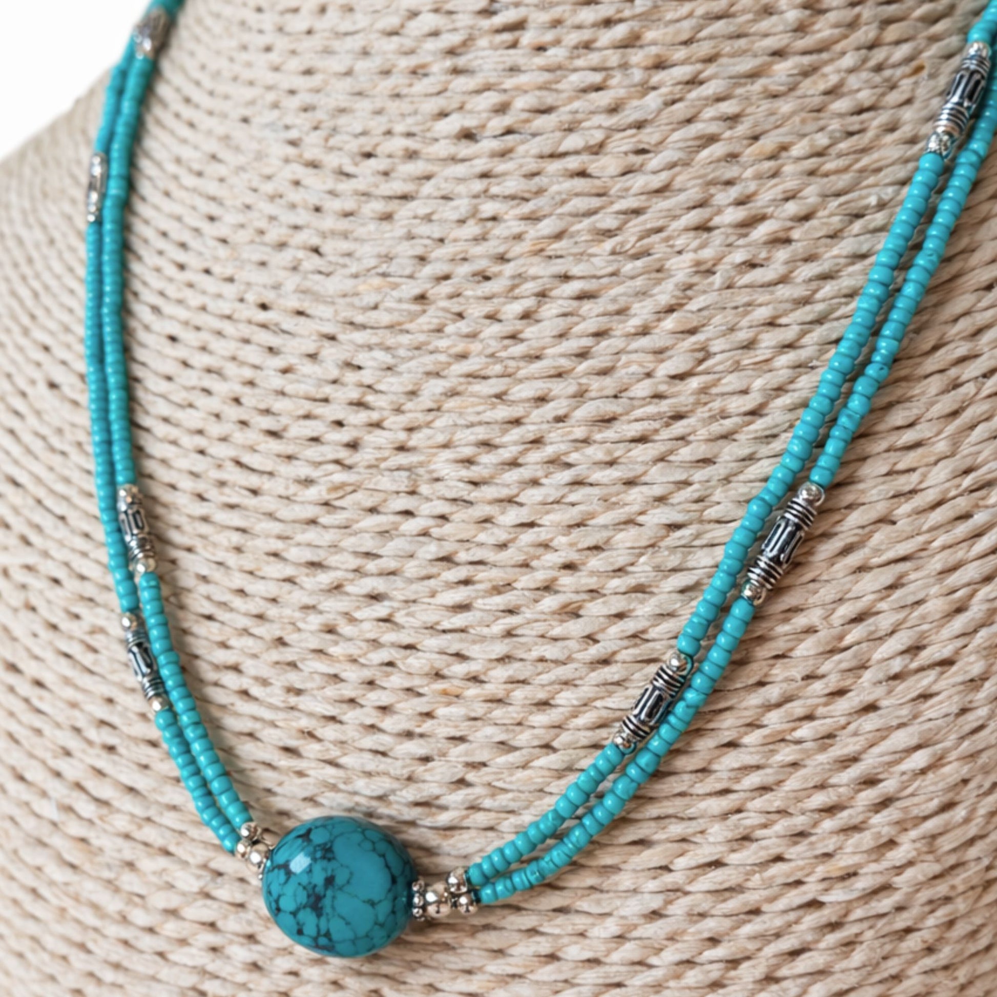 Collar de cuentas turquesa y plata, con una piedra central de turquesa, estilo bohemio y vibrante.