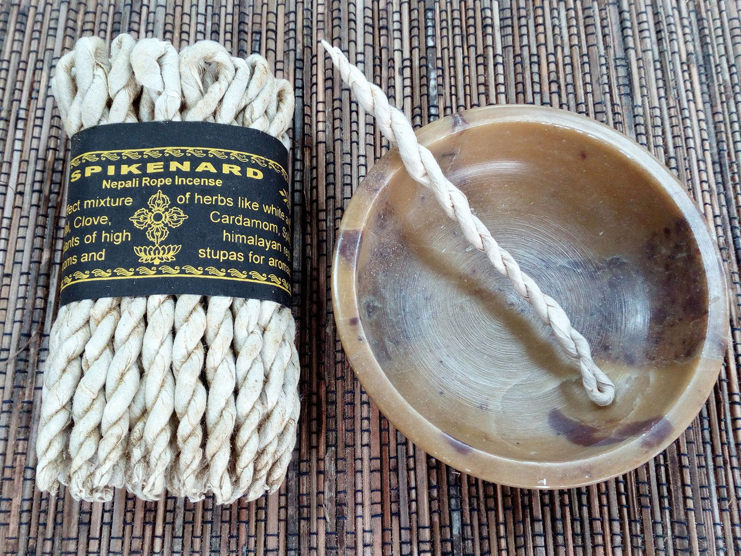Incienso de cuerda Spikenard, color beige, mezcla de hierbas, con soporte de cerámica en tono marrón.