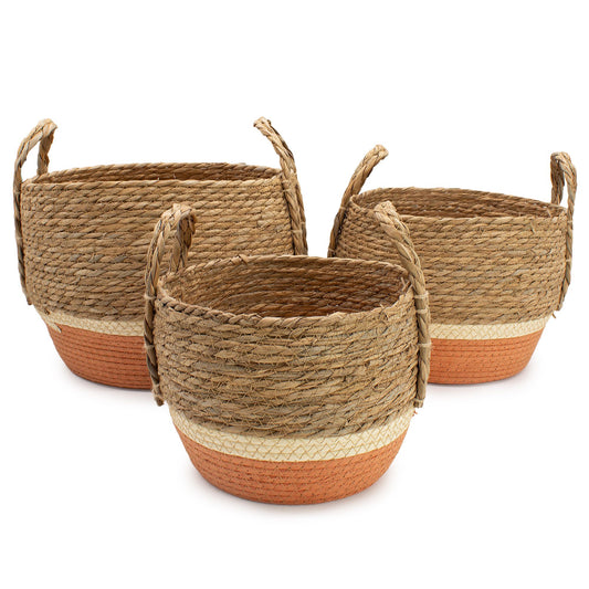 Set de 3 cestas tejidas de paja y pasto marino con asas, base naranja y detalle natural, estilo rústico y artesanal.