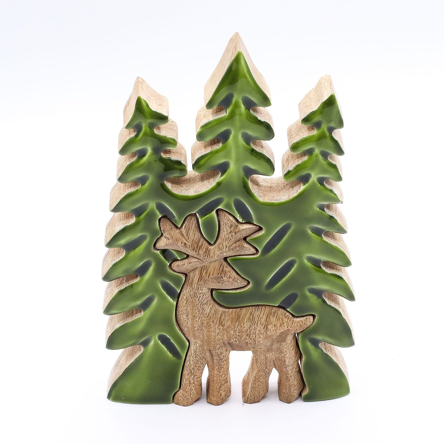 Figurita decorativa de ciervo en madera clara con verde, rodeada de pinos tallados, estilo rústico moderno.