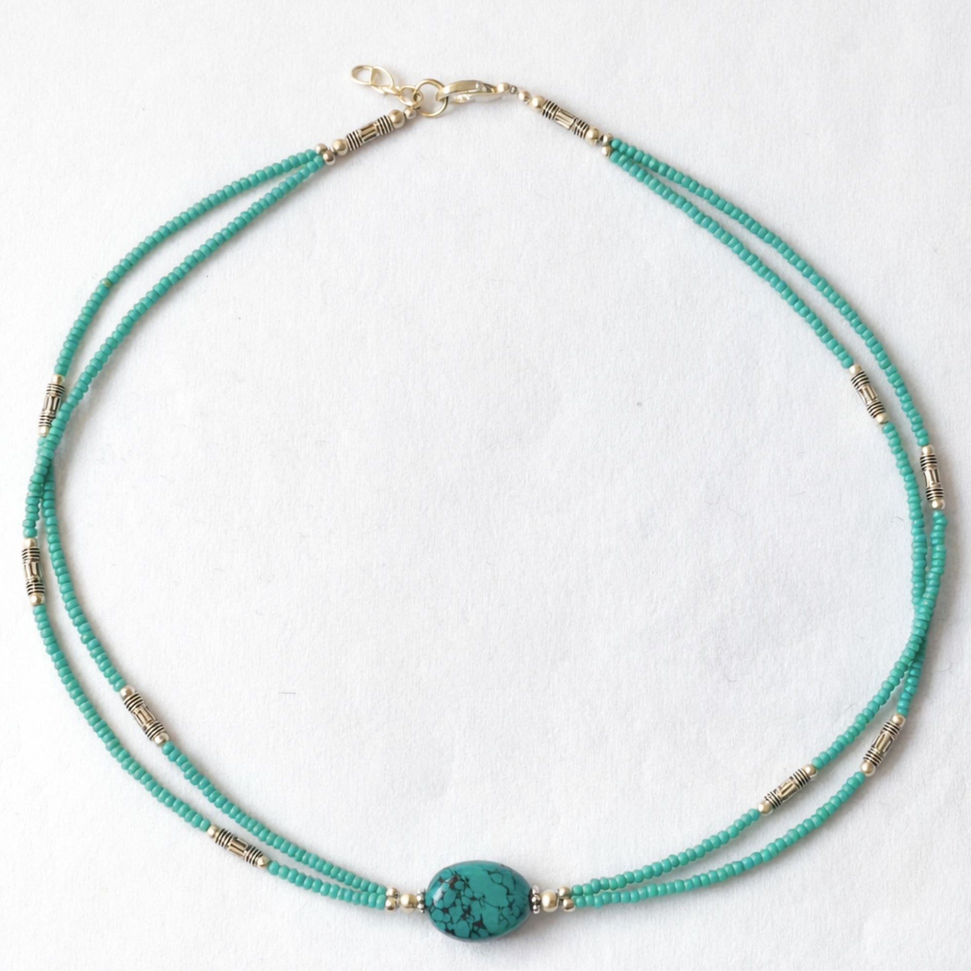 Collar de tres hilos en tonos turquesa con cuentas doradas y pieza central de turquesa, estilo bohemio.