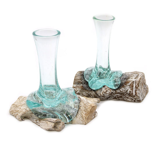 Dos floreros de vidrio fundido transparente con base de madera natural blanqueada de formas orgánicas.