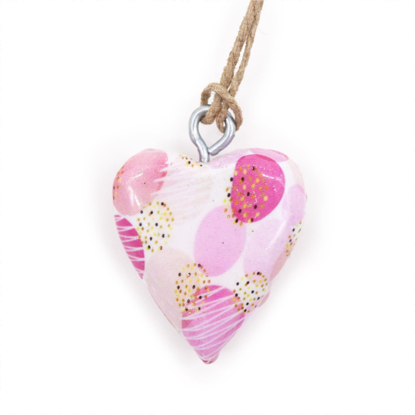 Corazón decorativo de cerámica en tonos rosa y blanco con patrones, colgado en cuerda natural.