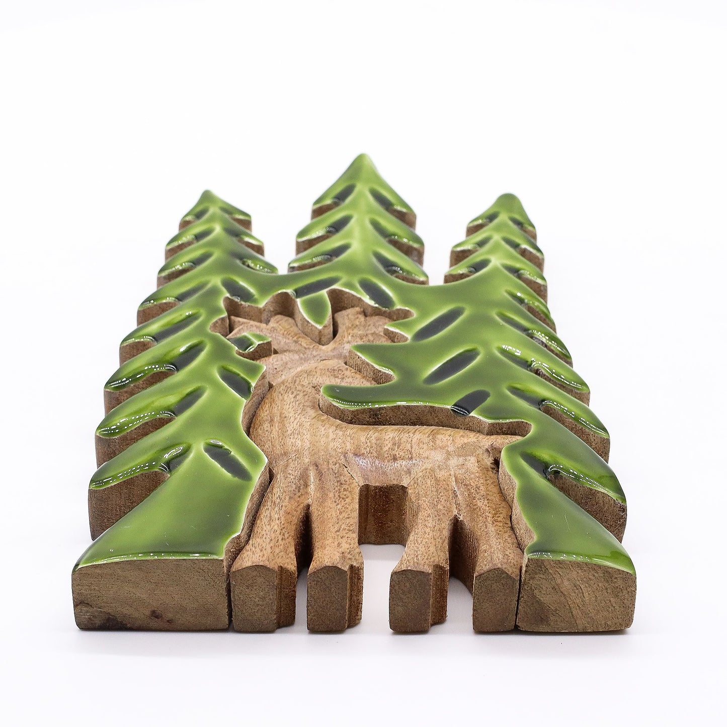 Figura decorativa de madera marrón con detalles verdes, representando un ciervo entre árboles estilizados.