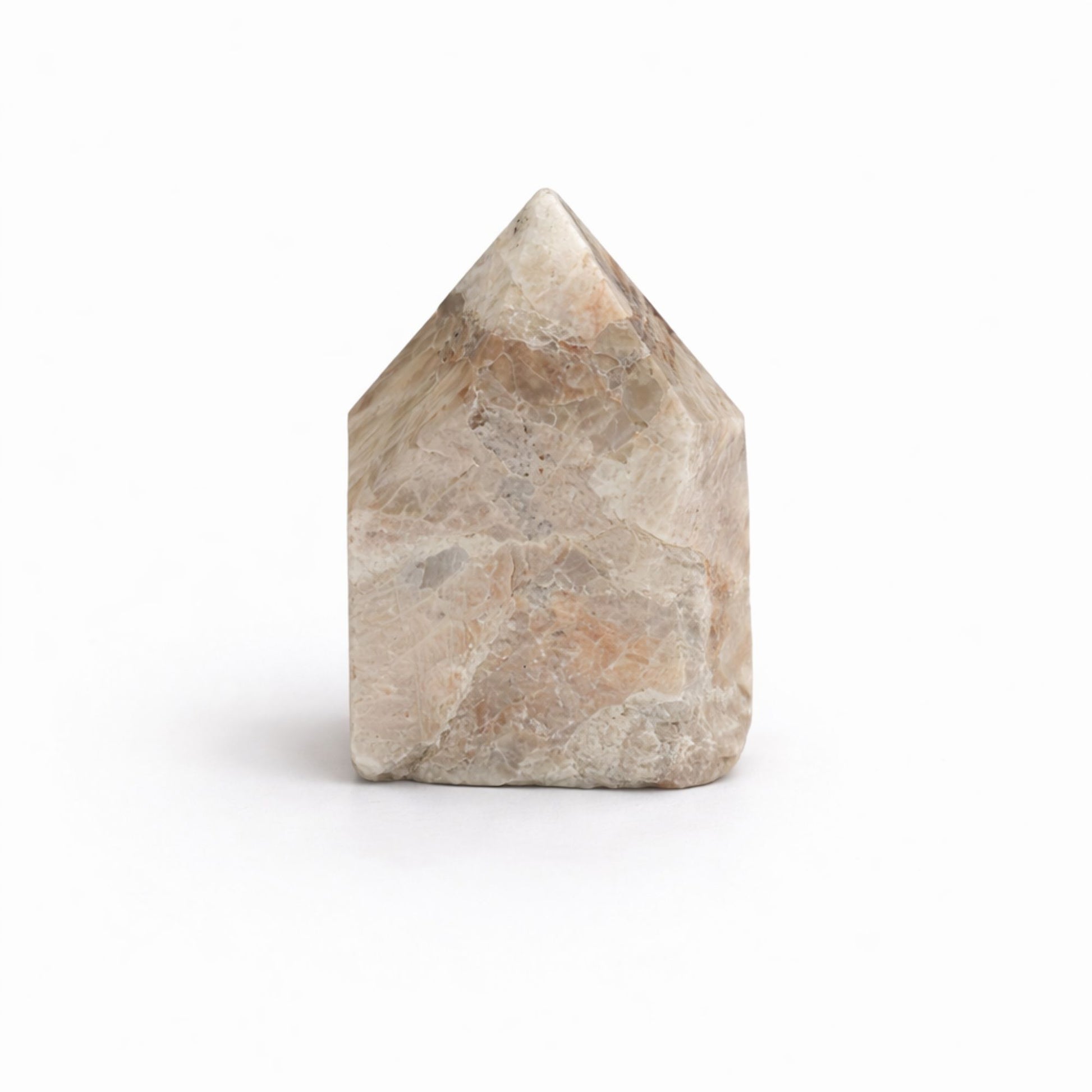 Piedra mineral en forma de casa, tonos beige y gris, superficie pulida, ideal para decoración y prácticas espirituales.