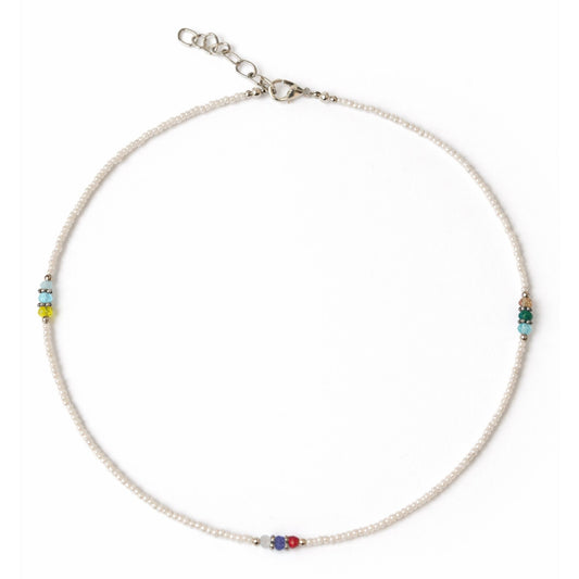 Collar de perlas blancas con cuentas de colores y cierre de plata, estilo elegante y moderno.