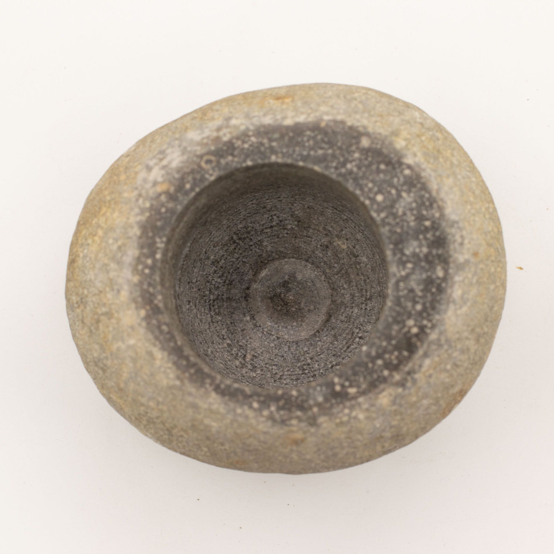 Maceta de piedra gris con textura irregular, estilo rústico, ideal para decoración de interiores o exteriores.