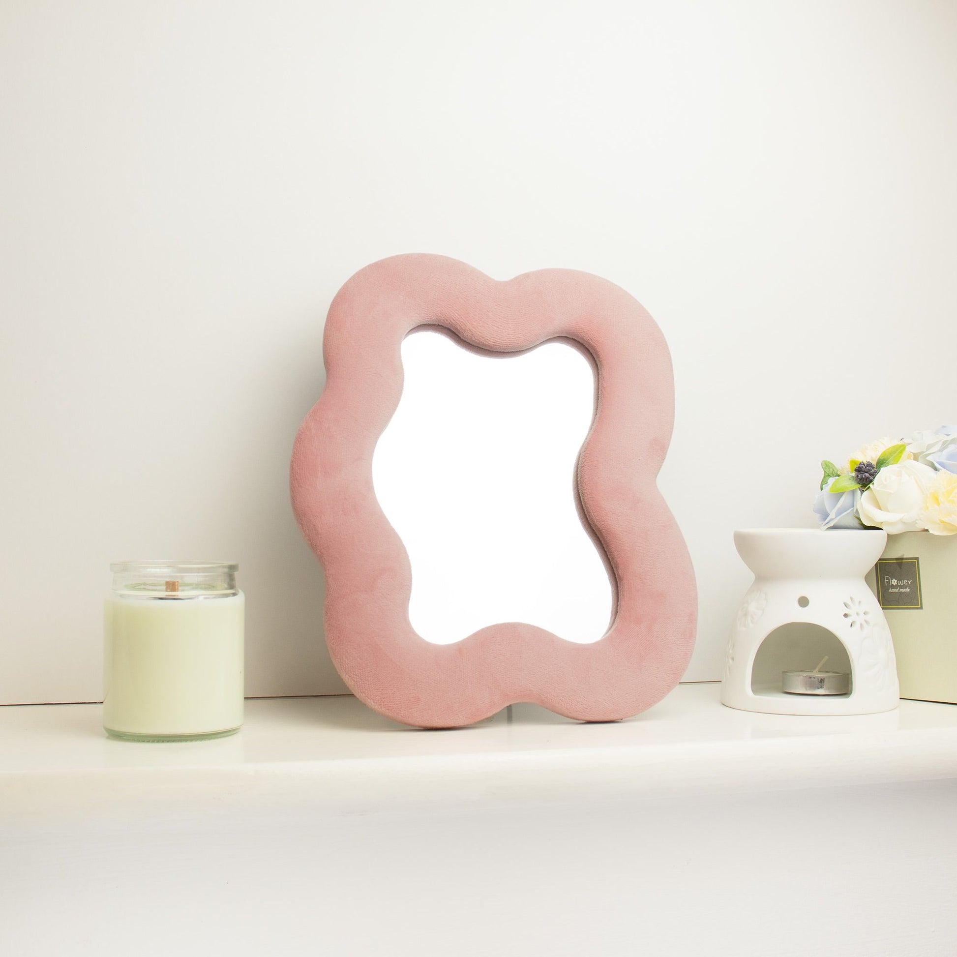 Espejo rosa en forma de nube con borde de terciopelo, ideal para decoración contemporánea.