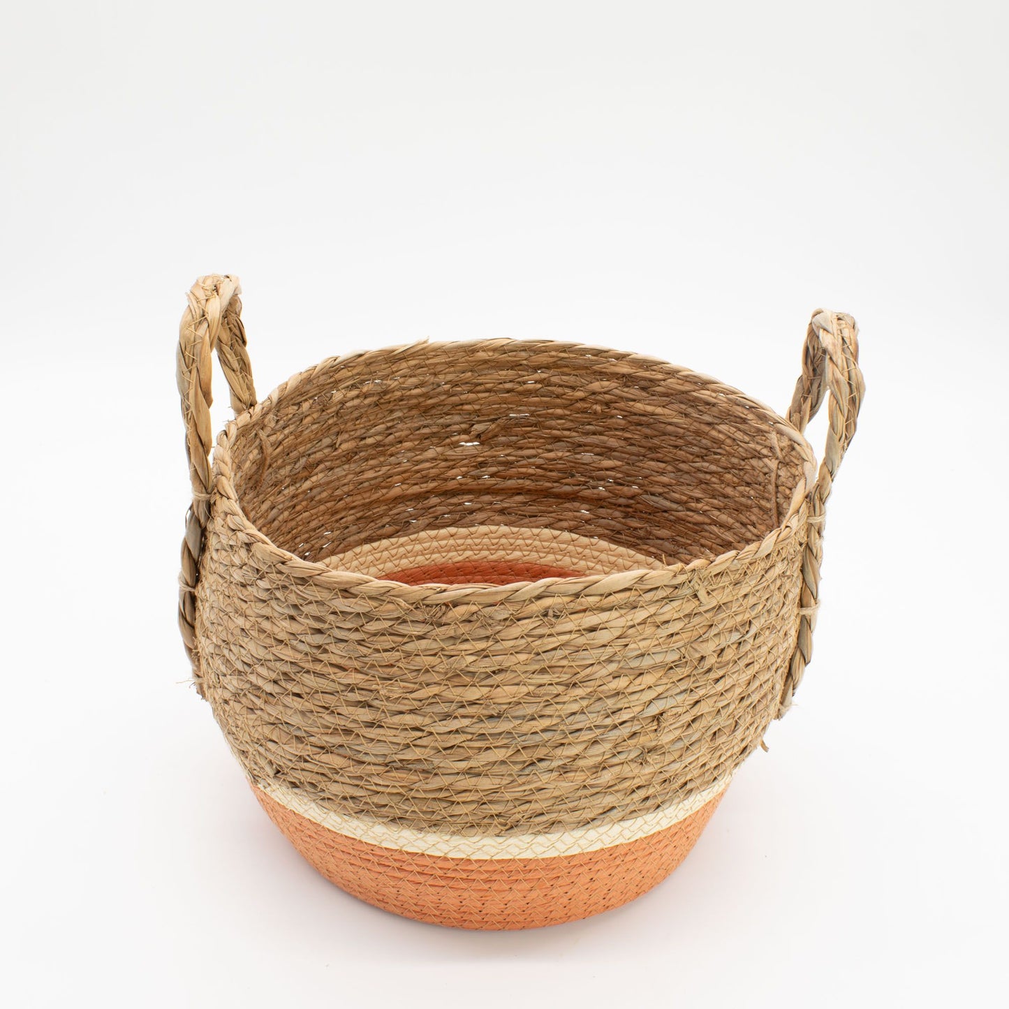 Cesta de pasto marino tejida con asas, tono natural y base naranja, estilo rústico artesanal sobre fondo blanco.