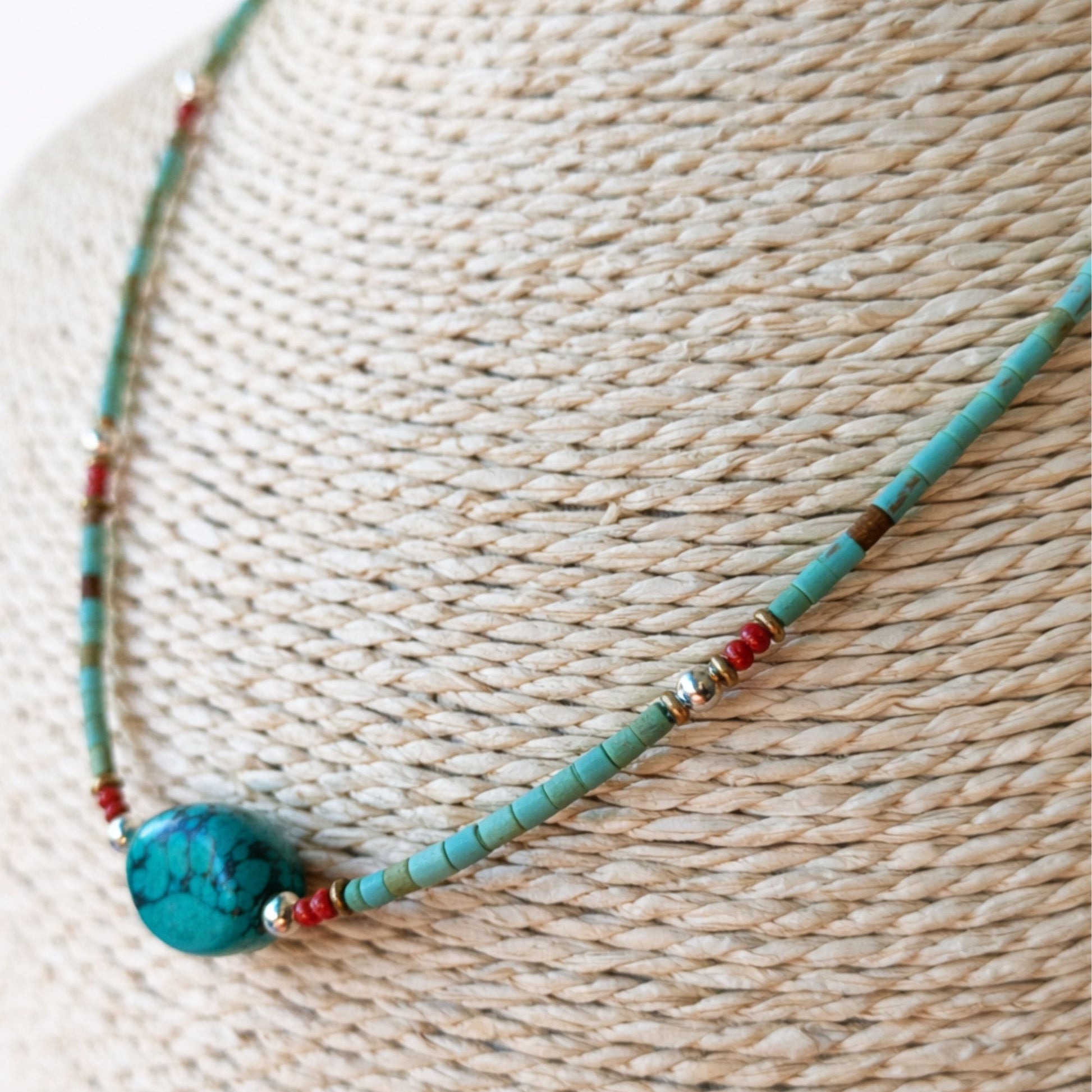Collar artesanal de turquesa y cuentas rojas, con detalles en plata. Estilo bohemio y colores vibrantes.