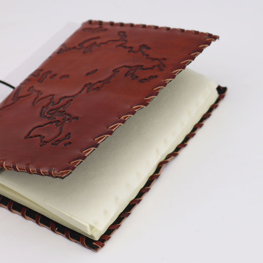 Cuaderno de piel marrón con bordado, páginas en color crema, estilo rústico y artesanal, ideal para escritura.