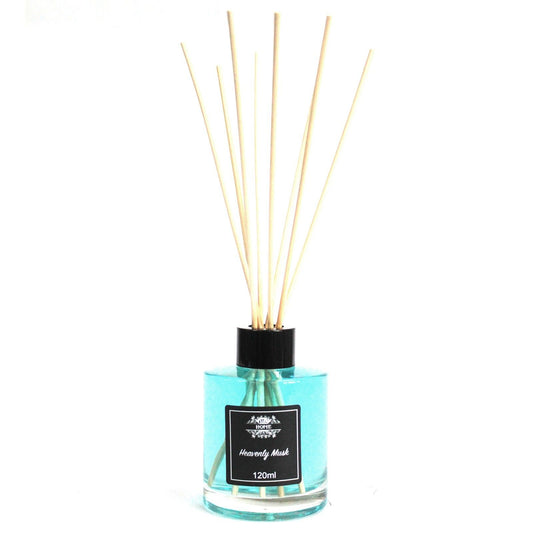 Difusor de vidrio cilíndrico con líquido azul, tapa negra y varillas de madera sobre fondo blanco.