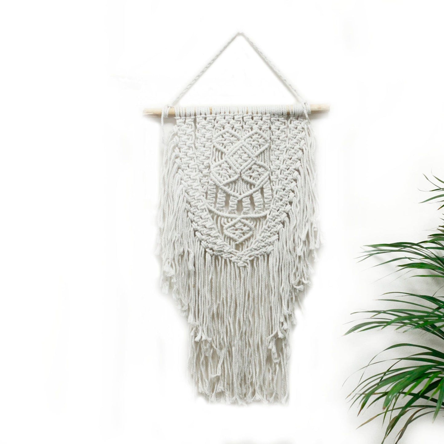 Macramé decorativo blanco con flecos, estilo boho, ideal para adornar paredes.