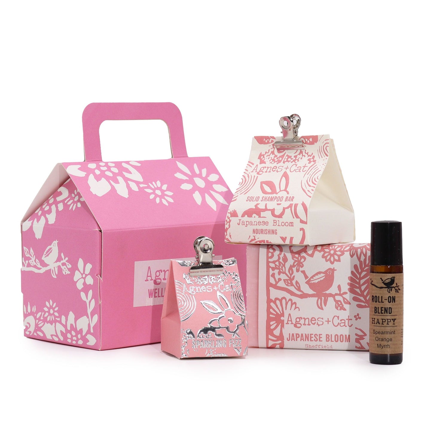 Set de regalo Agnes & Cat en caja rosa con champú, jabón, efervescente y aceite roll-on, todo con diseño floral y ave.
