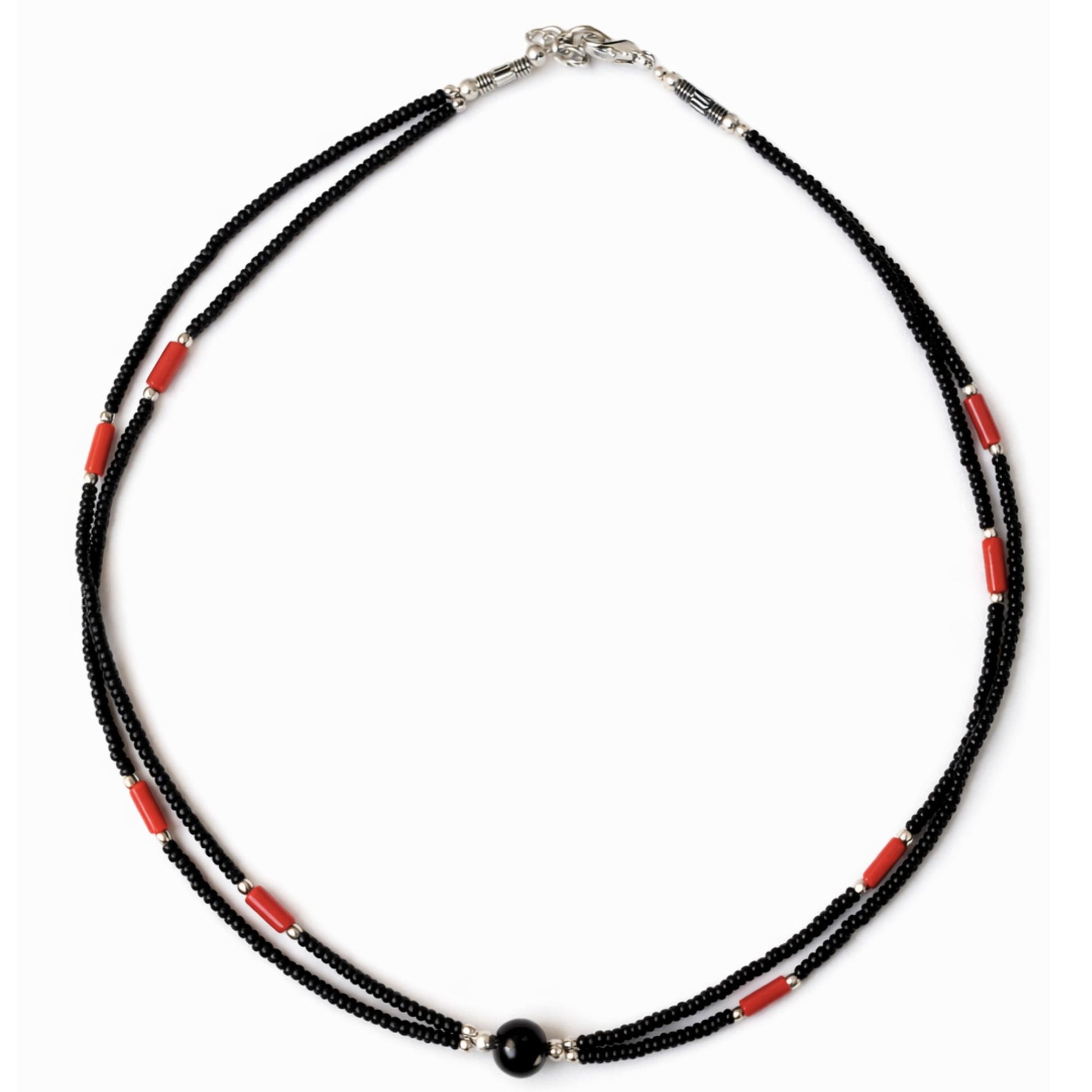Collar de cuentas negras y rojas, con detalles plateados, estilo bohemio.