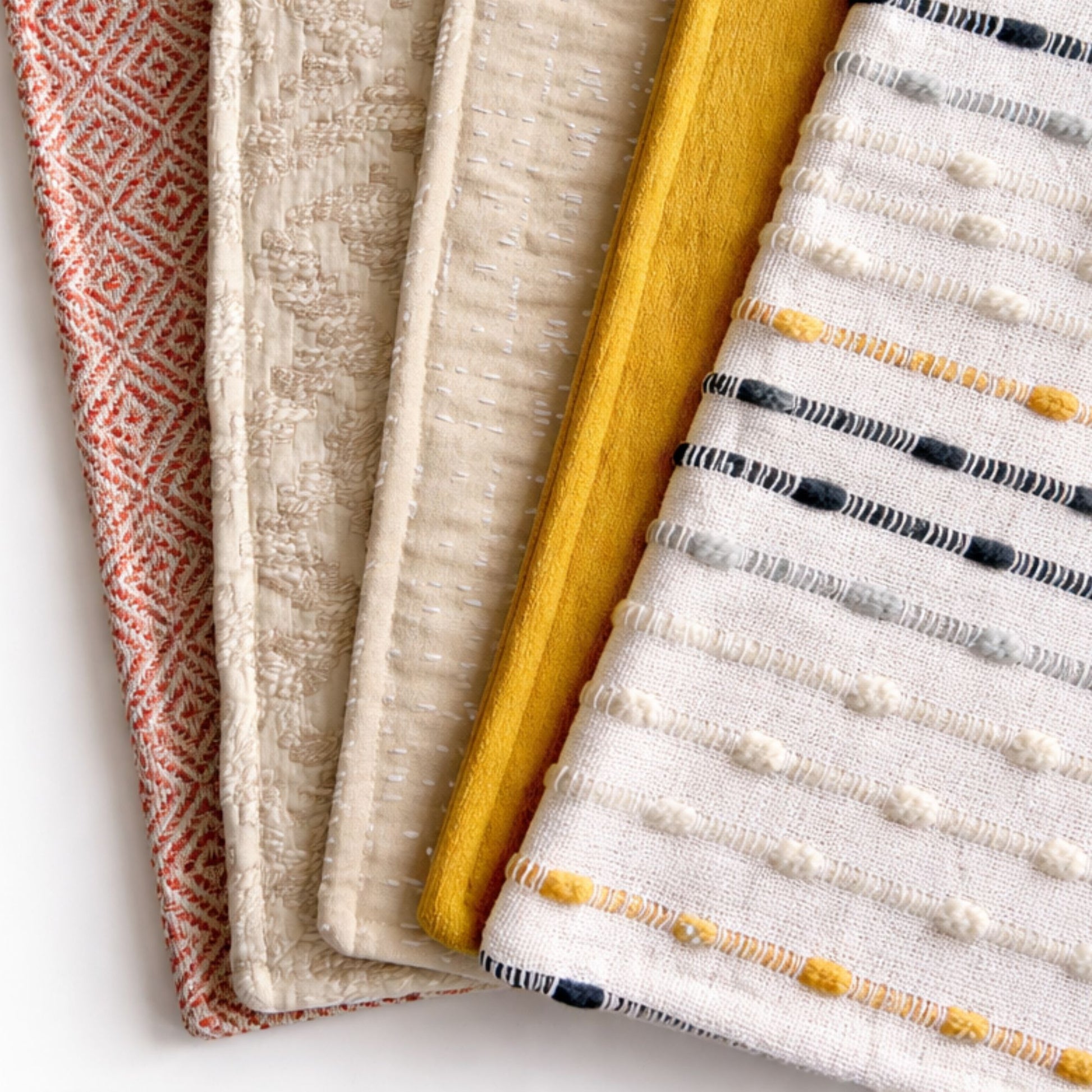Conjuntos de telas decorativas en tonos rojo, beige, amarillo y blanco, con texturas modernas y patrones elegantes.