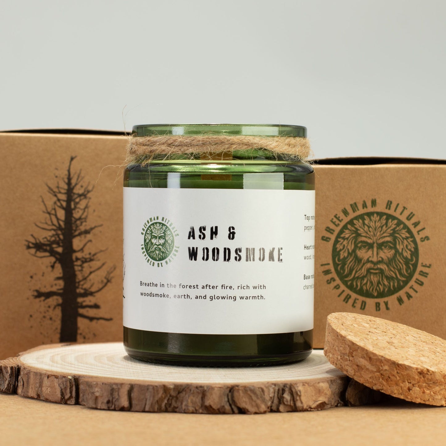 Vela verde "Ash & Woodsmoke" en tarro de vidrio, con cuerda natural, aroma a leña y tierra, estilo rústico.