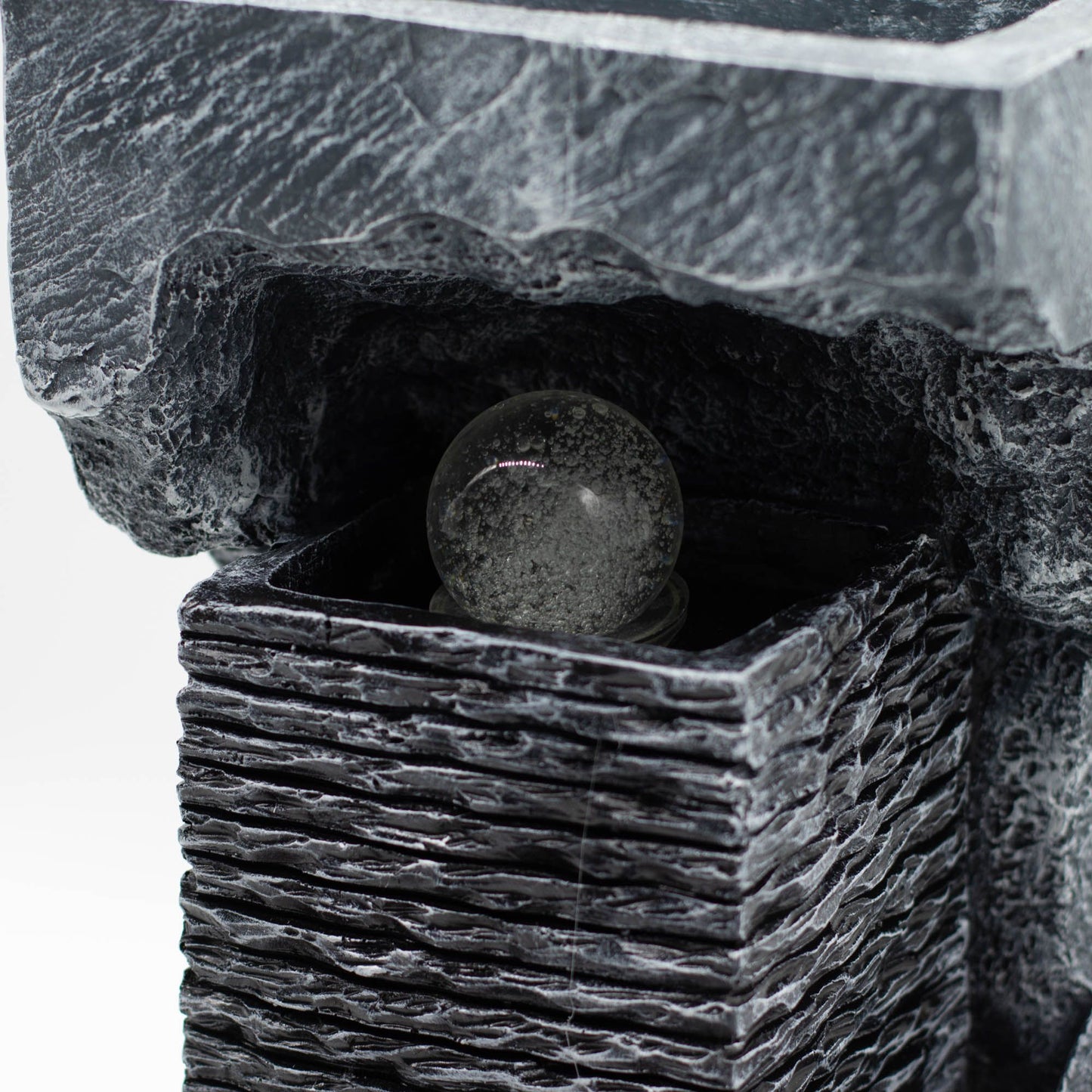 Fuente de jardín de piedra artificial negra con bola de cristal clara, estilo moderno y elegante.