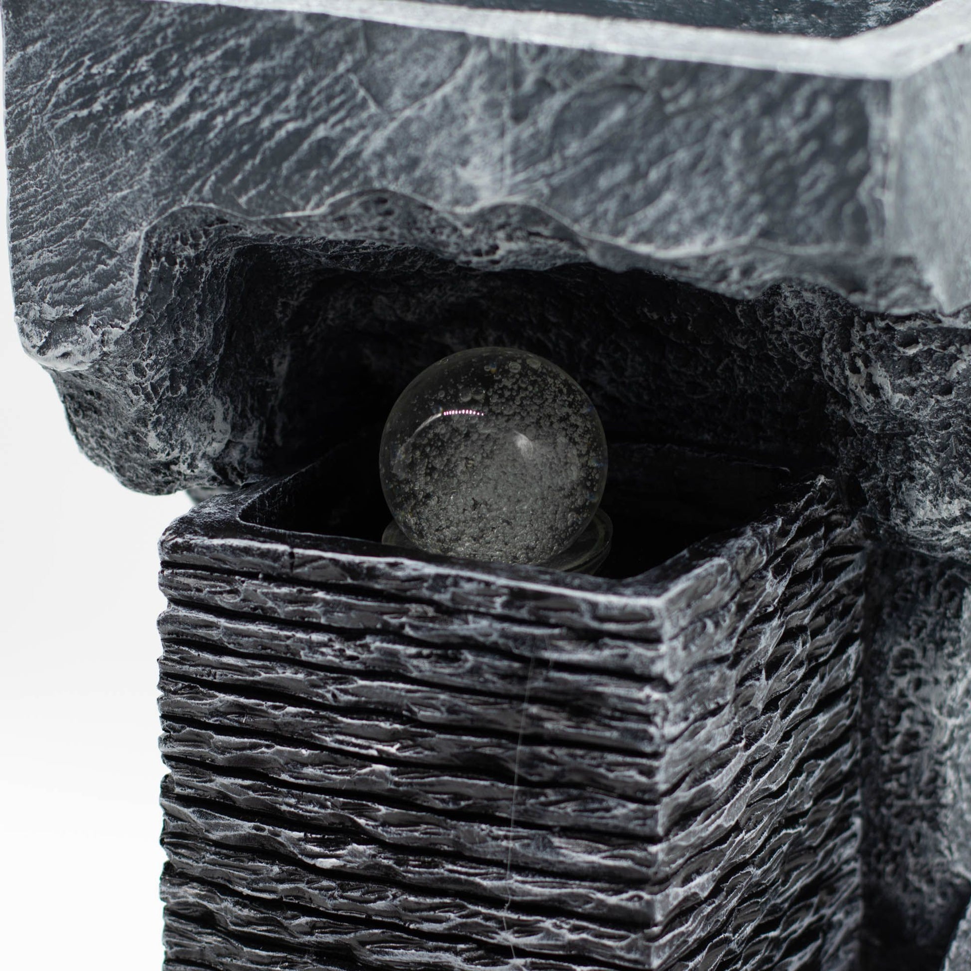 Fuente de jardín de piedra artificial negra con bola de cristal clara, estilo moderno y elegante.
