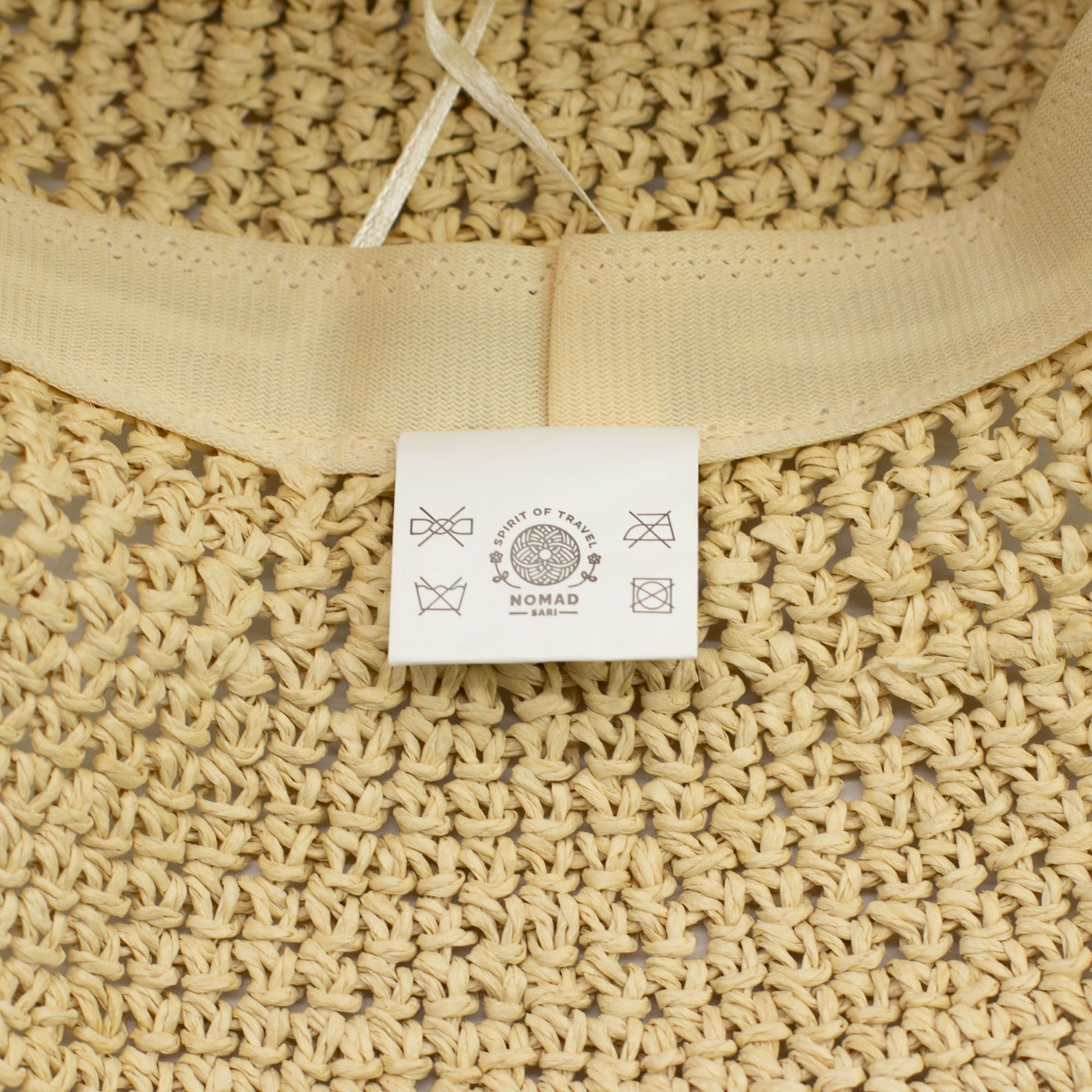 Bolsa de yute color natural con etiqueta blanca, estilo bohemio, ideal para usar en verano.