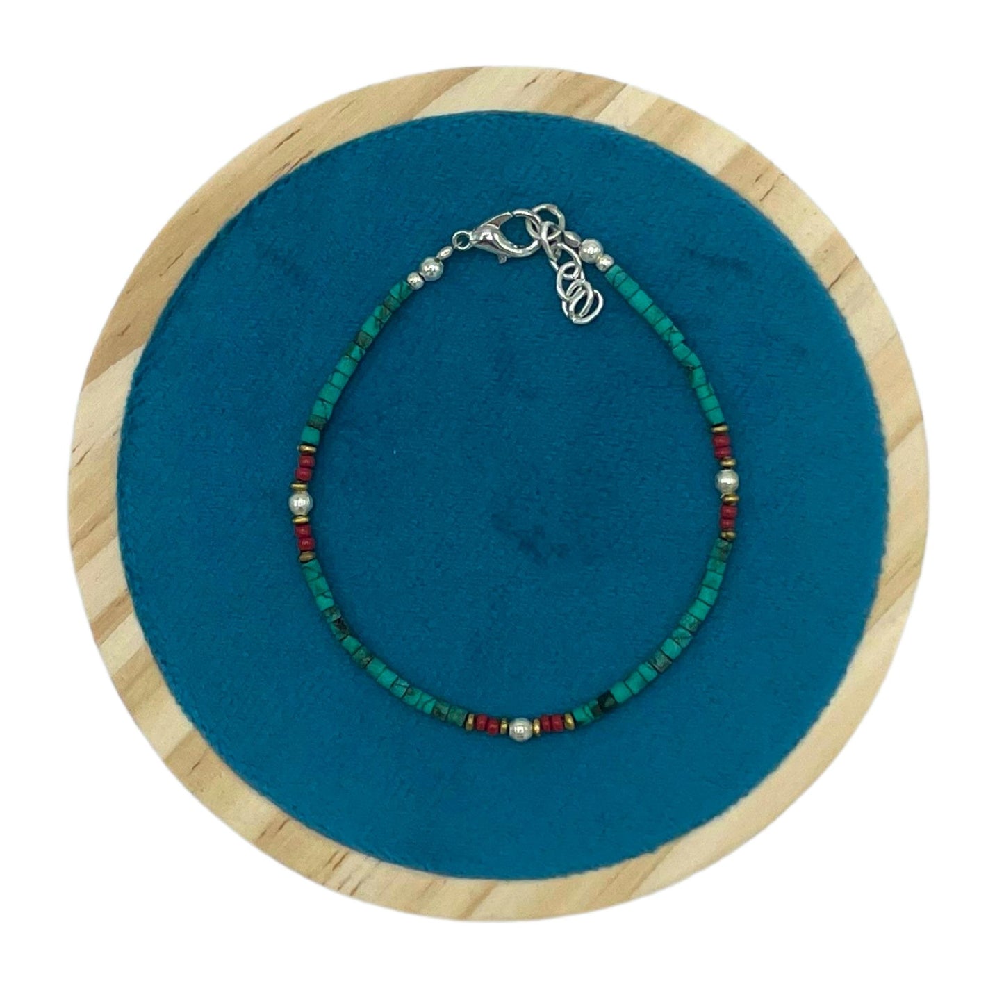 Pulsera de cuentas turquesas y rojas con detalles en plata, estilo bohemio y ajustable.