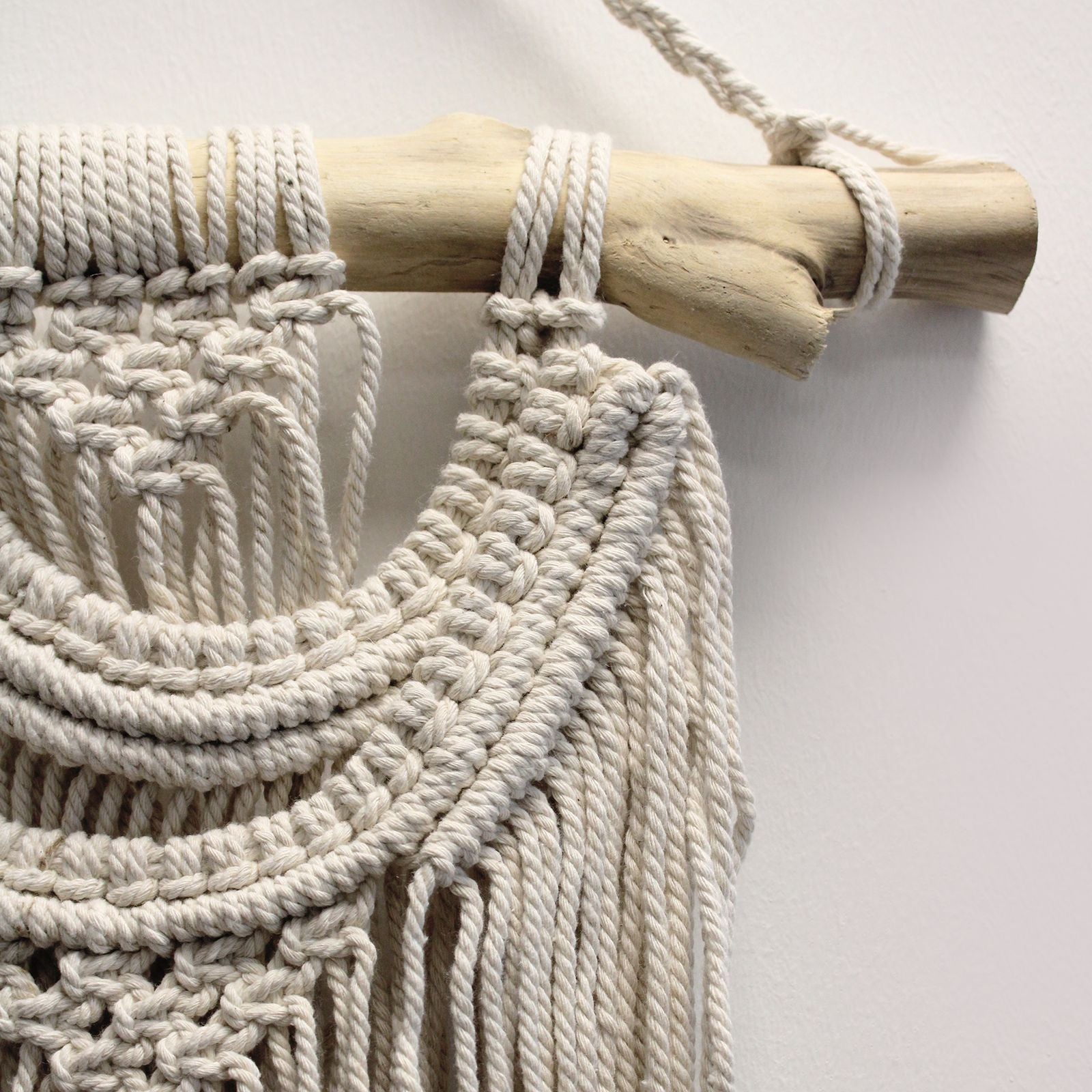 Macramé bohemio en algodón natural, color crema, decorado con barra de madera para pared.