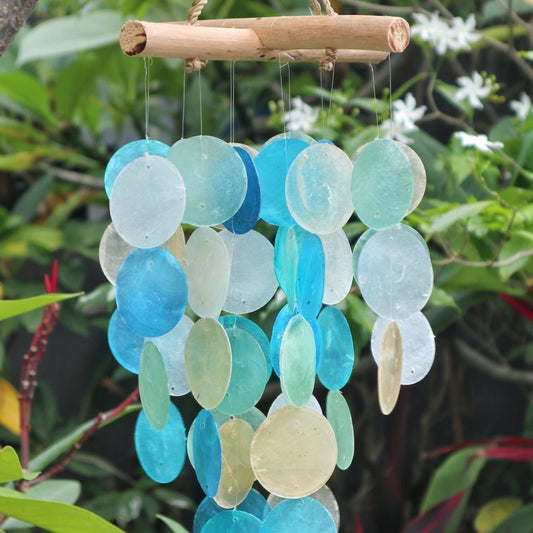 Carillón decorativo con discos circulares de nácar en tonos azules y perla, colgados de una estructura de madera natural.