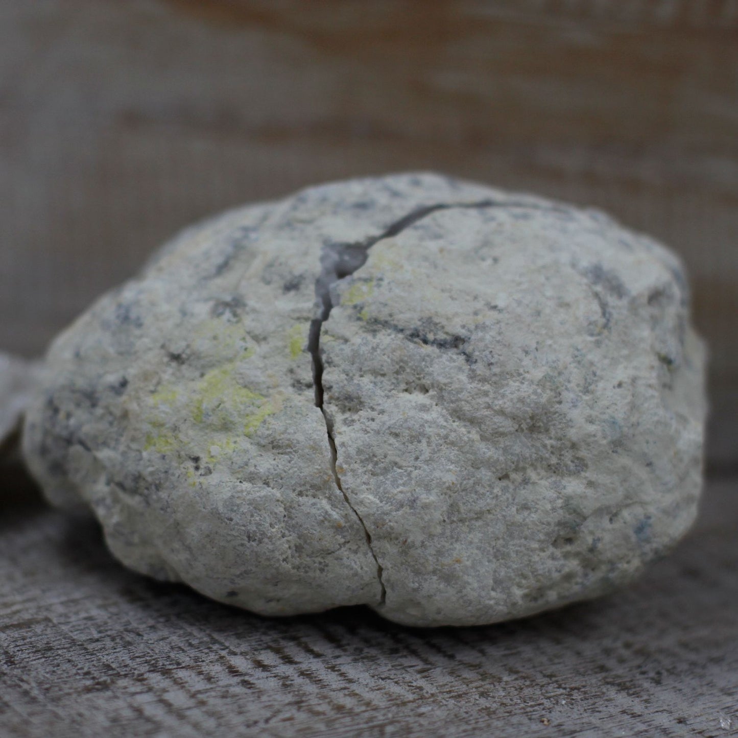 Piedra decorativa gris claro con vetas amarillas, textura natural y forma irregular, ideal para jardinería.