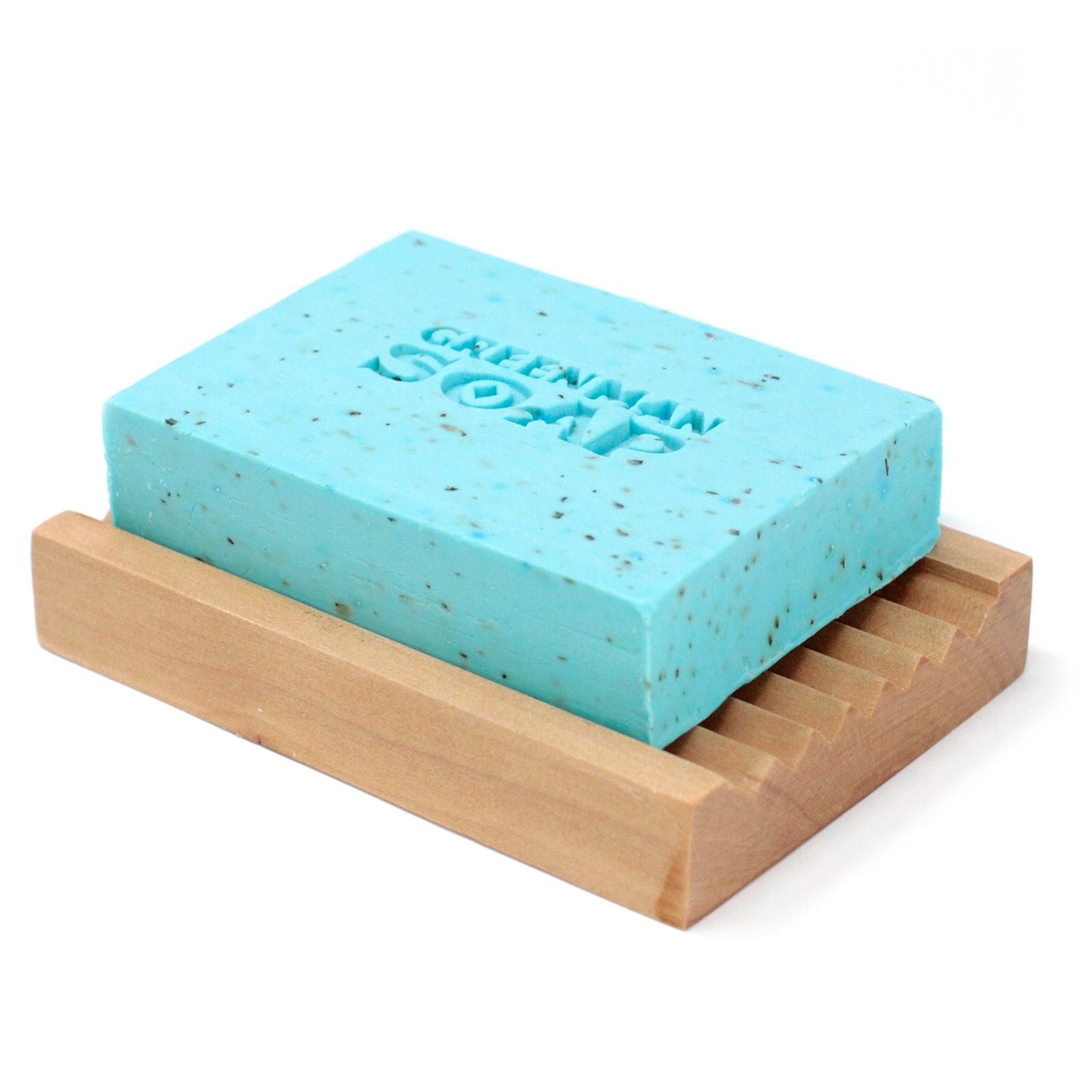 Jabón azul claro con motas, grabado "Greenman Soap", sobre una jabonera de madera acanalada. Fondo blanco.