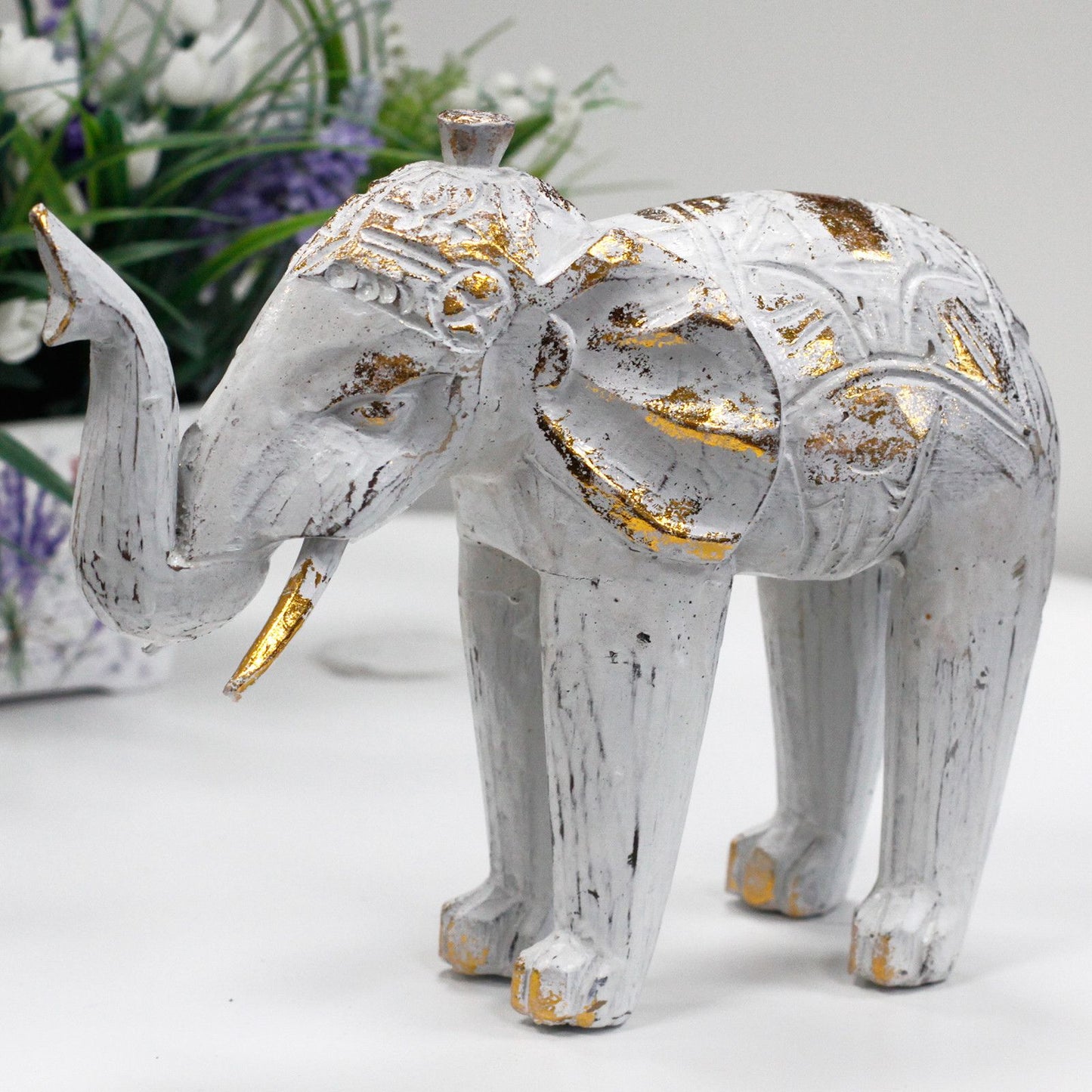 Elefante decorativo de madera blanco y dorado con detalles tallados, estilo vintage. Ideal para decoración del hogar.