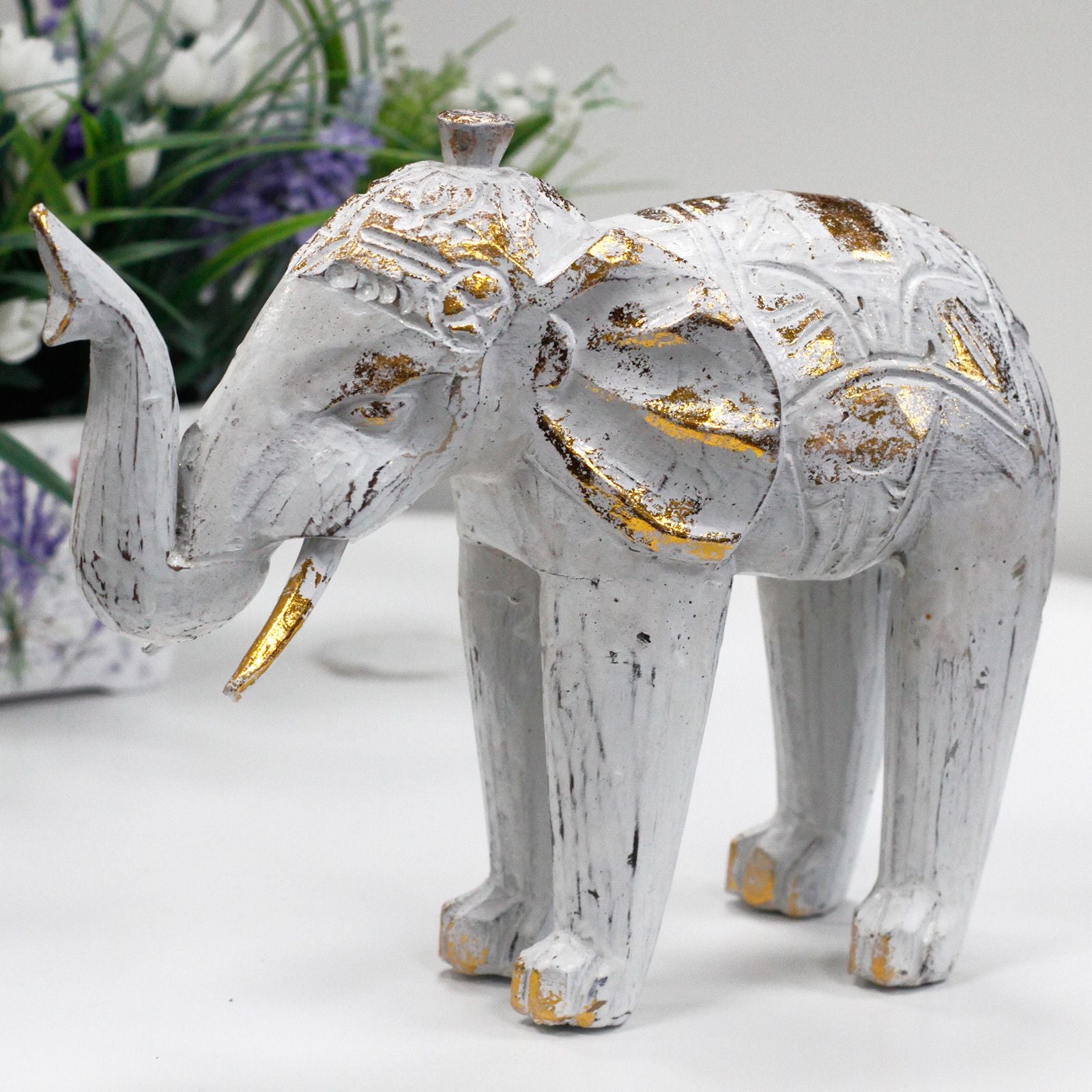 Elefante decorativo de madera blanco y dorado con detalles tallados, estilo vintage. Ideal para decoración del hogar.