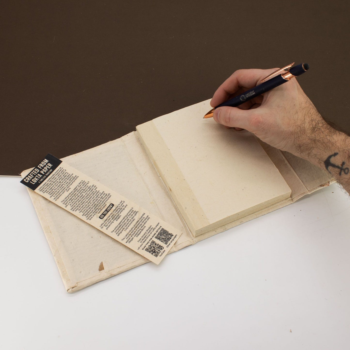 Cuaderno de papel reciclado en color crema con marcador, cubierta de tela beige, estilo artesanal y ecológico.