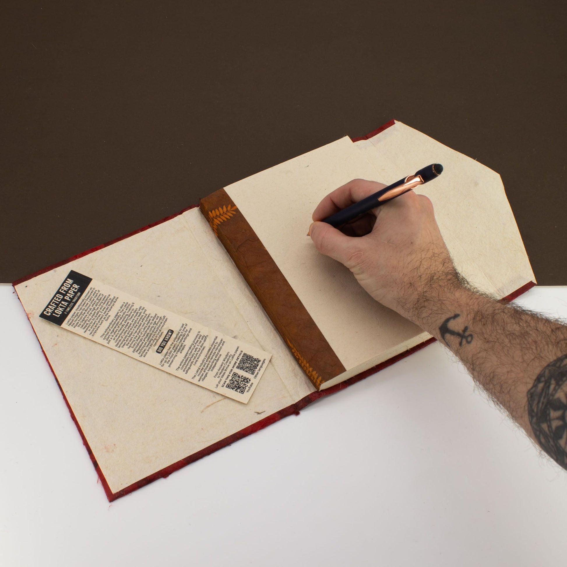 Cuaderno de cuero marrón con hojas de papel reciclado, estilo artesanal, ideal para escritura y bocetos.