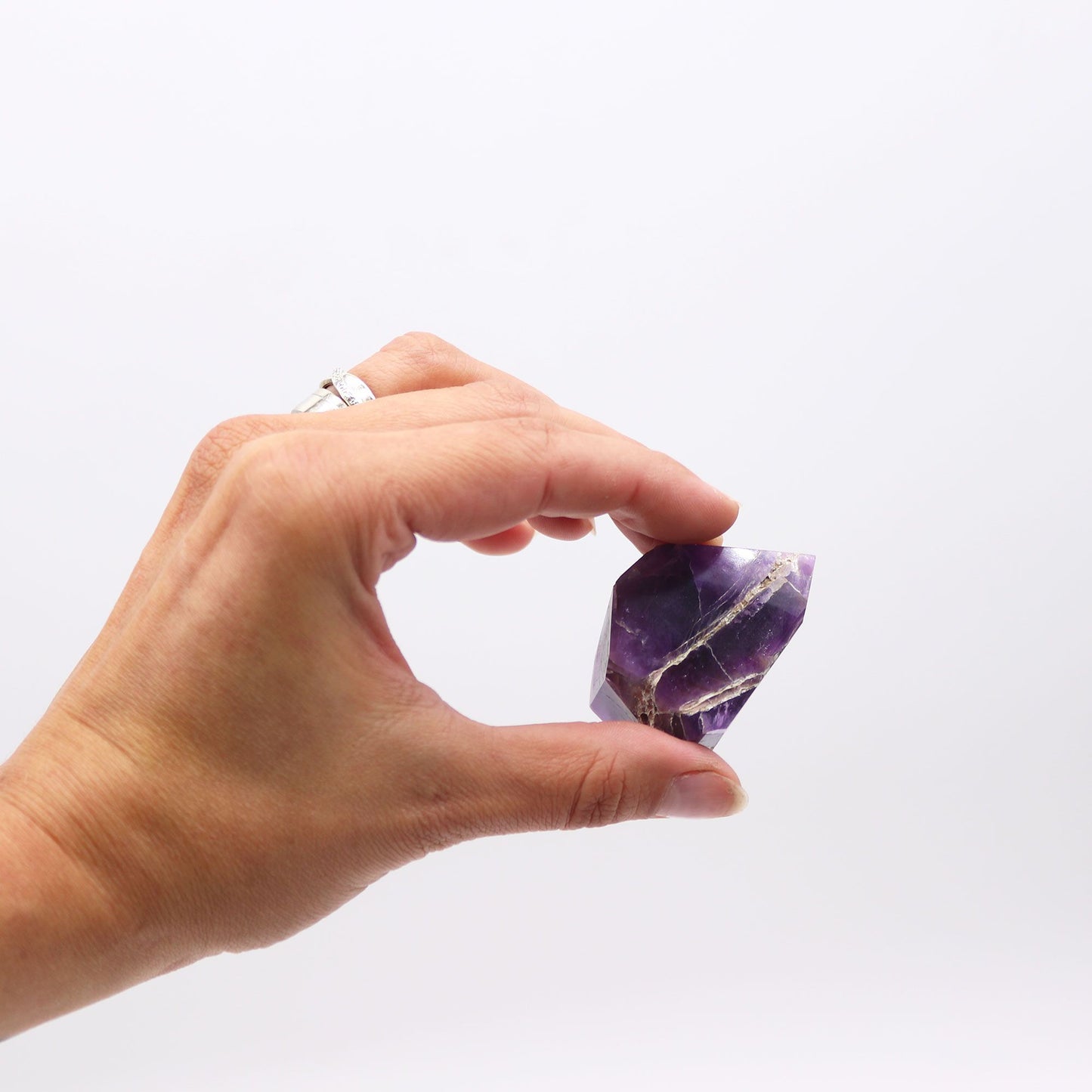 Cristal de amatista morado con veta dorada, corte elegante, ideal para decoración o colección.